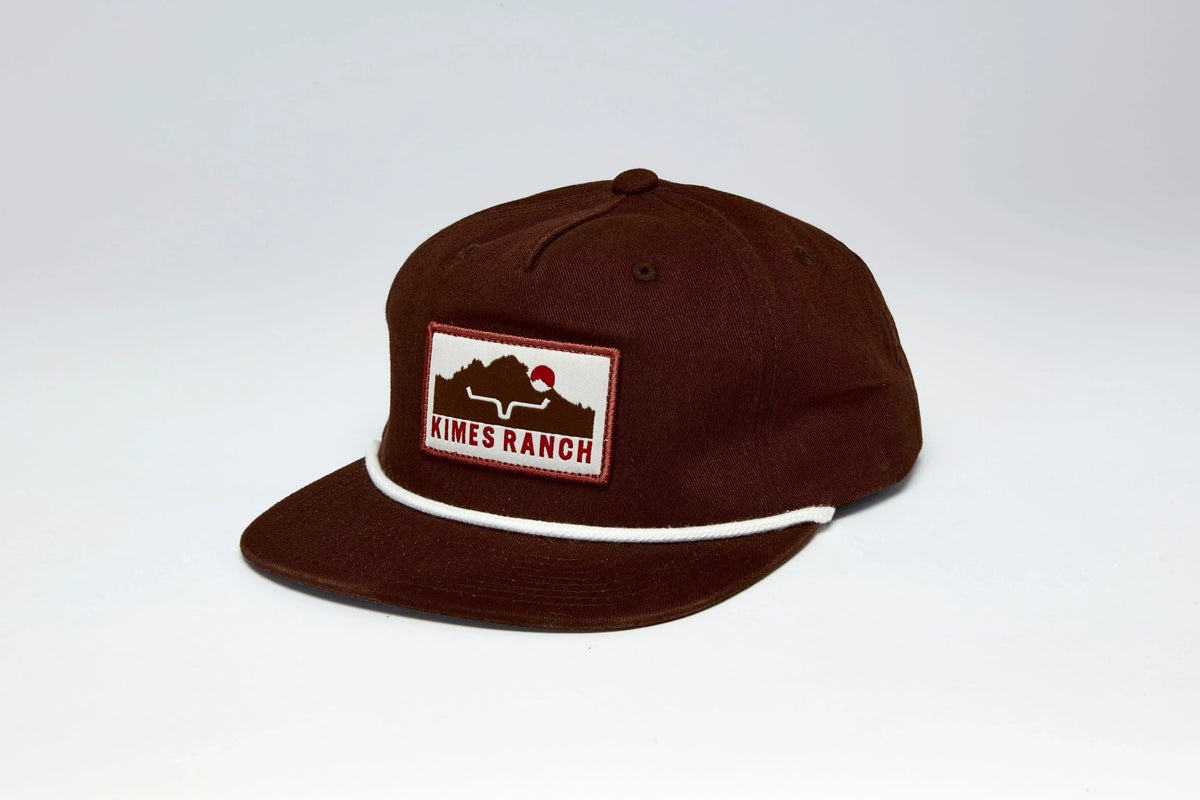 Kimes Ranch Kick Back hat in Dark Brown, side view, with a front Kimes Ranch logo patch and white piping on the brim