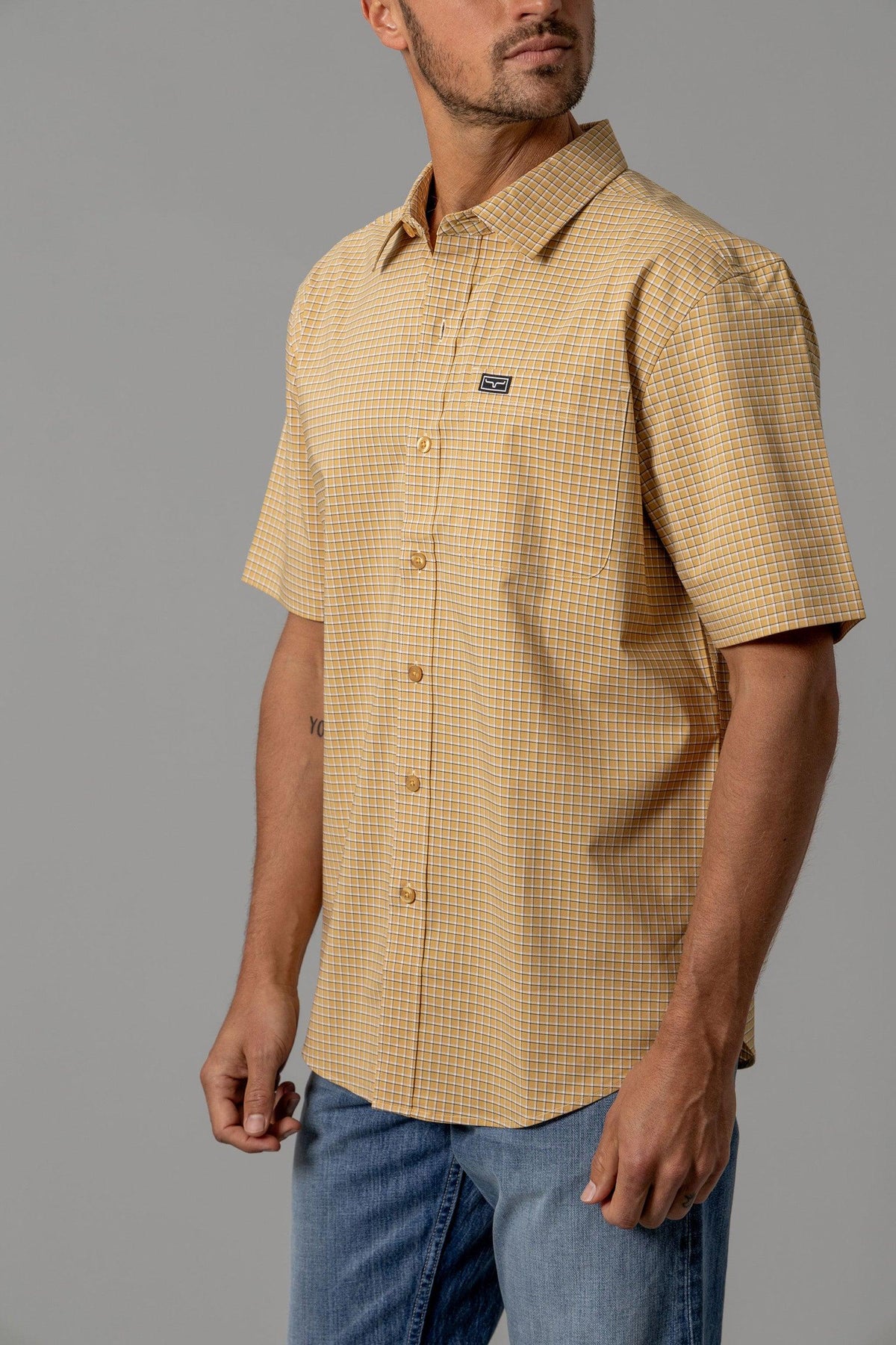 Kimes Ranch MC Cooper short sleeve dress shirt in Gold with a check pattern and chest logo