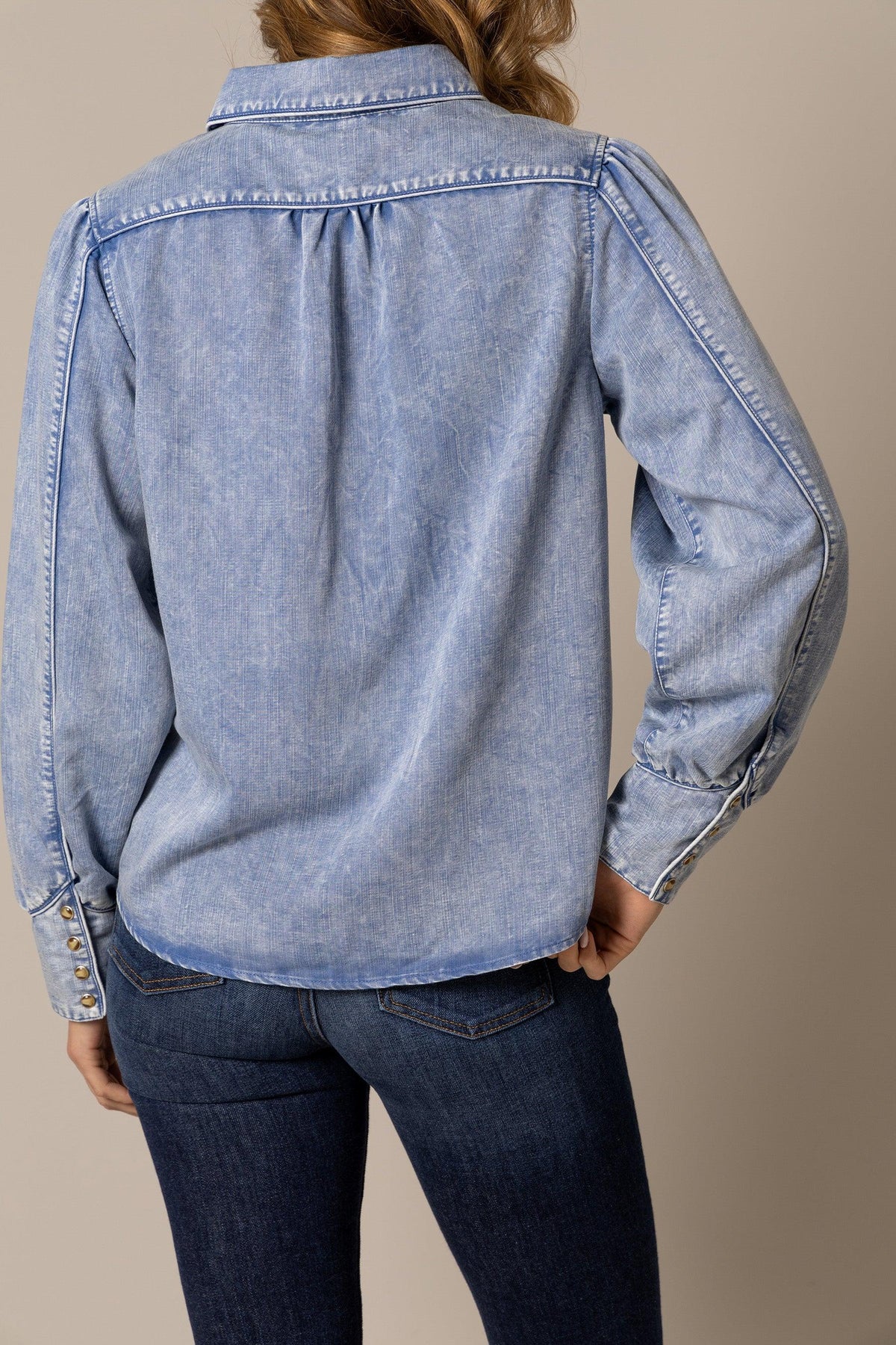 Kimes Ranch Mae top in Light Wash Indigo, back view, with a back yoke and buttoned cuffs