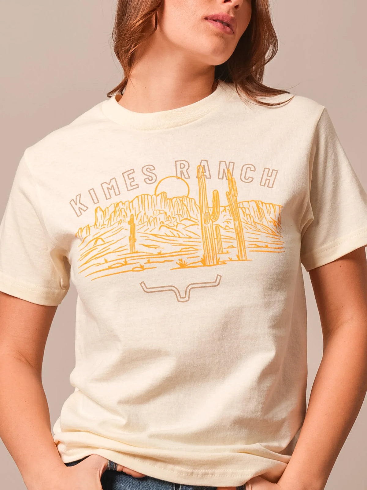 Kimes Ranch Mountain Badge shirt in Cream with a desert landscape graphic and Kimes Ranch logo