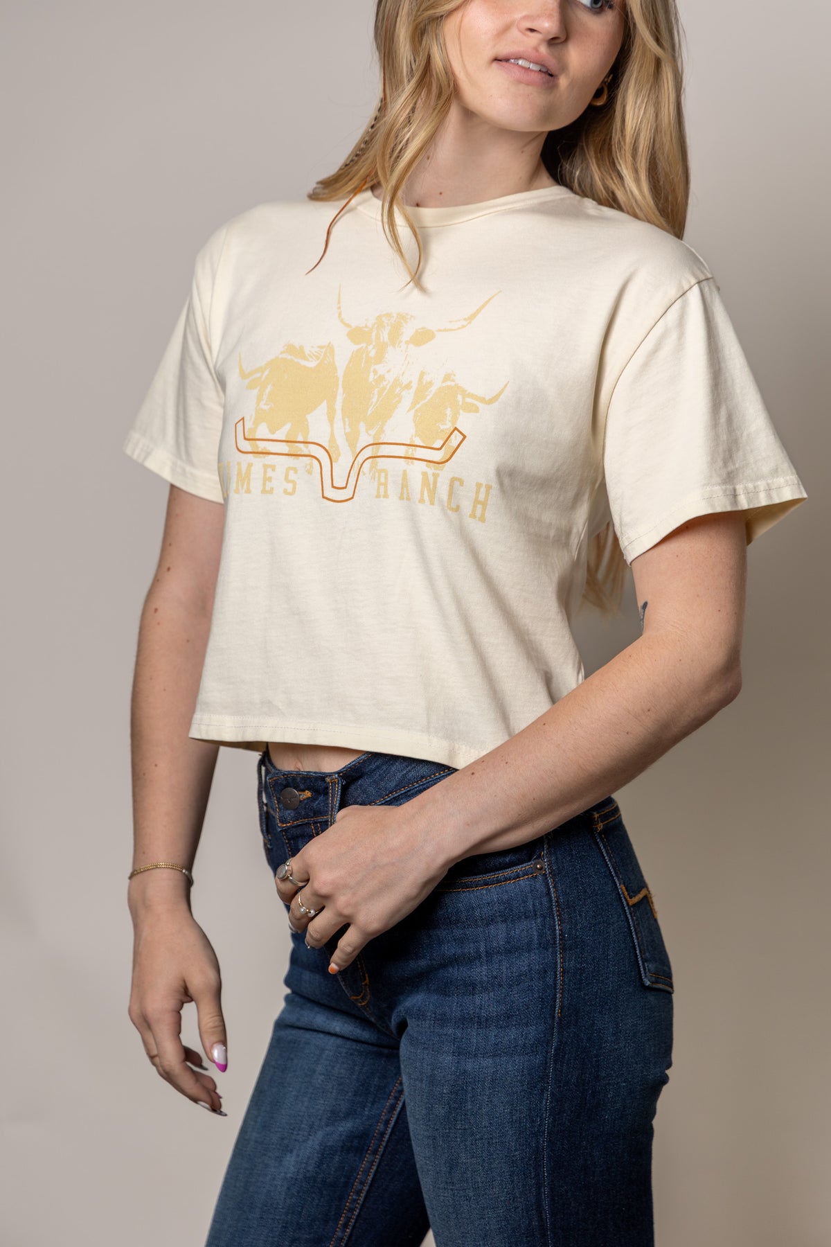 Kimes Ranch Movin' Out Ivory shirt with a graphic of three longhorns and the brand name