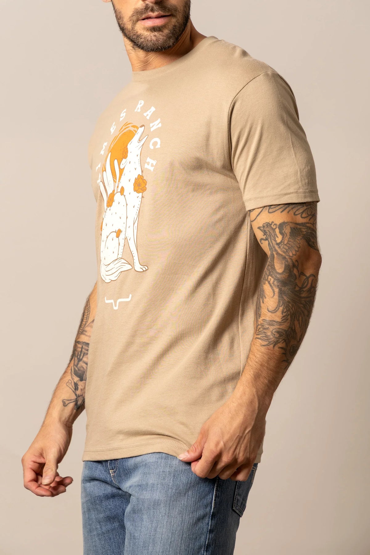Kimes Ranch Night Call, side view, Tan short sleeve shirt with a howling coyote graphic and Kimes Ranch logo