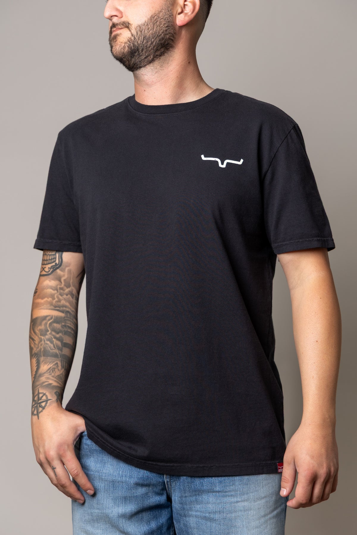 Kimes Ranch Not Our First, side view, Black short sleeve t-shirt with a white logo on the chest