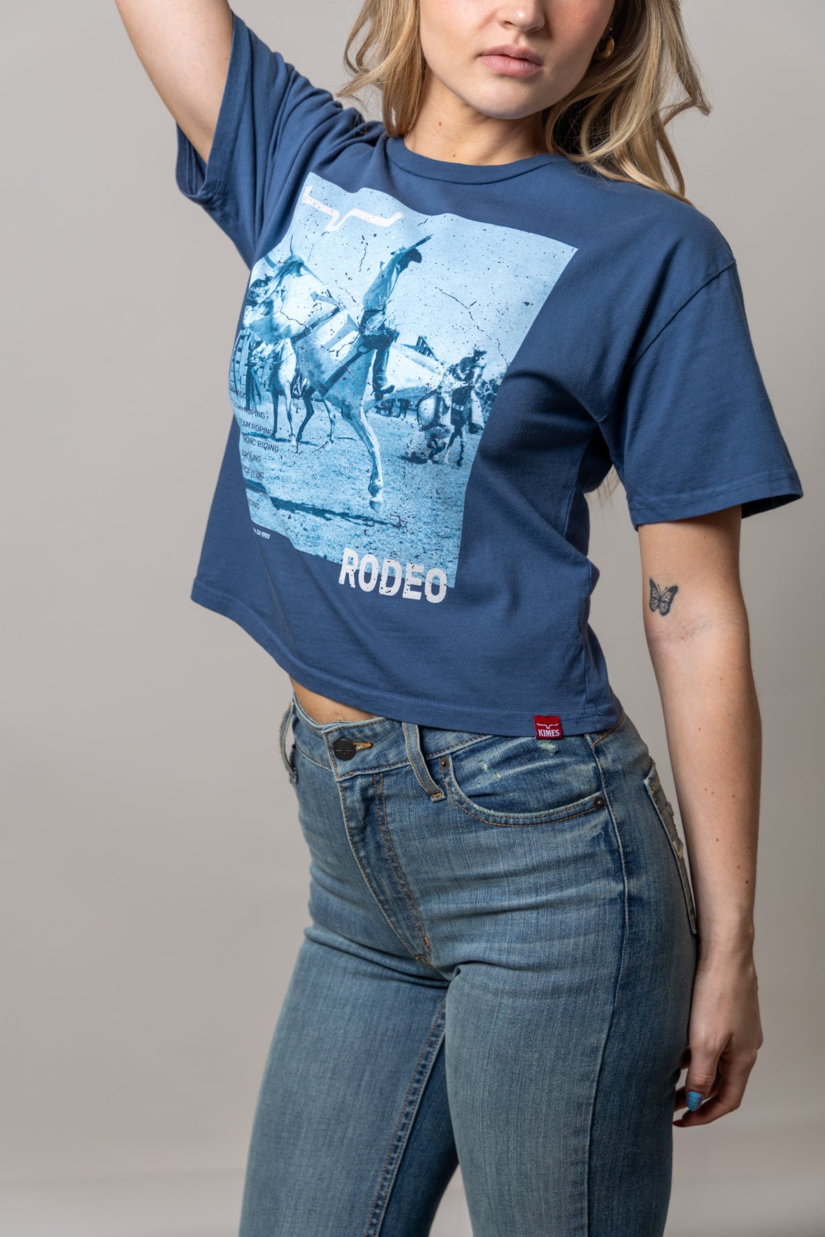Kimes Ranch Not Our First shirt in Dark Blue, side view, with a vintage rodeo graphic and RODEEO text