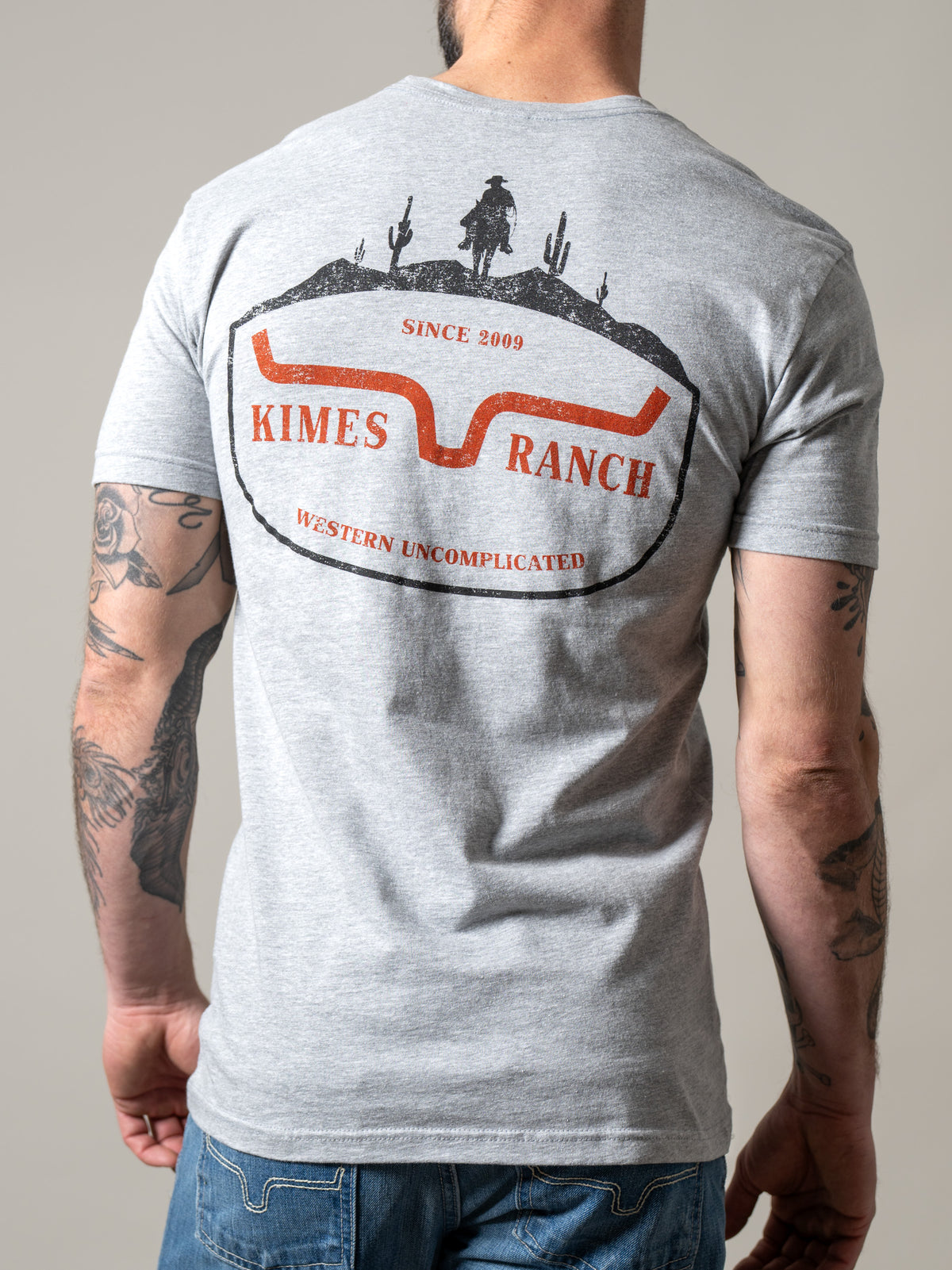 Kimes Ranch Old West shirt in Heather Grey, back view, with a back graphic featuring a cowboy silhouette