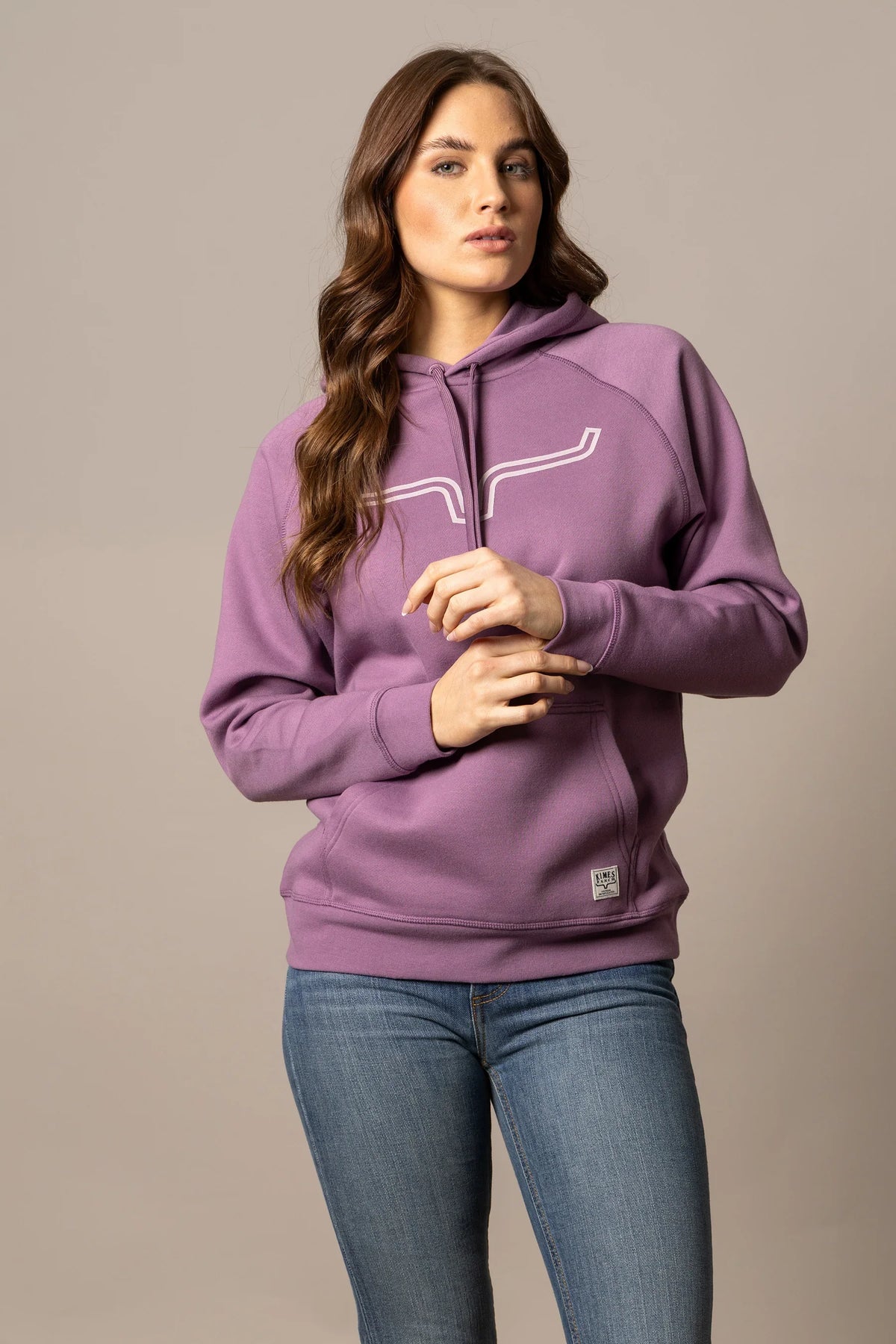 Kimes Ranch Ladies Outlier Hoodie in Lilac with a white logo graphic on the chest and a front kangaroo pocket