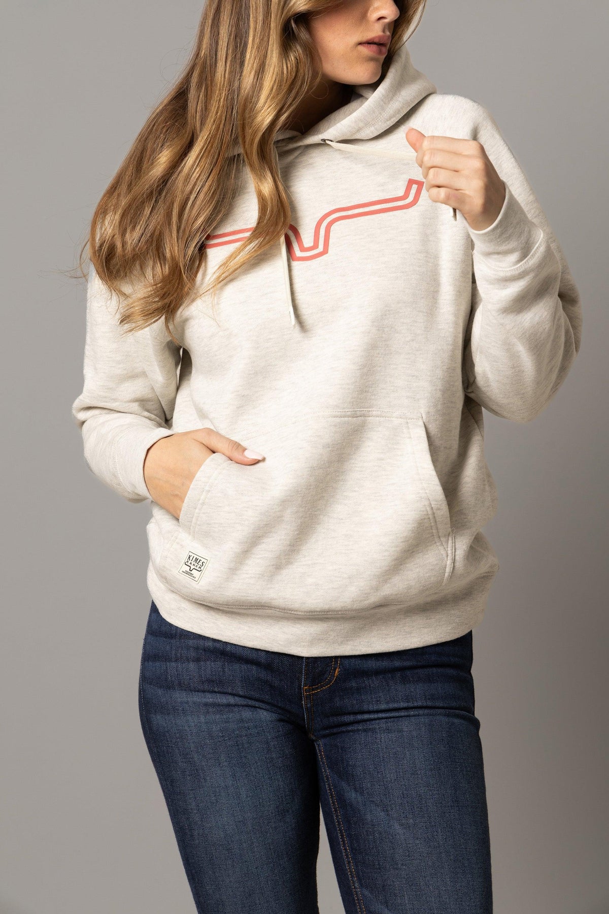 Kimes Ranch Ladies Outlier Hoodie in Oatmeal Heather with a red graphic and kangaroo pocket