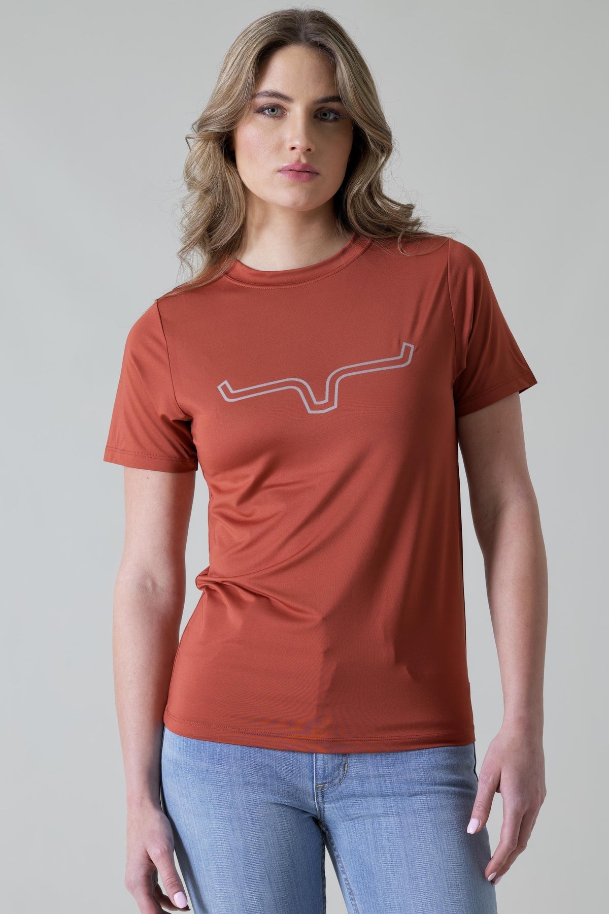 Kimes Ranch Ladies Outlier Tech Tee Shirt in Rust with a white outline steer logo on the chest