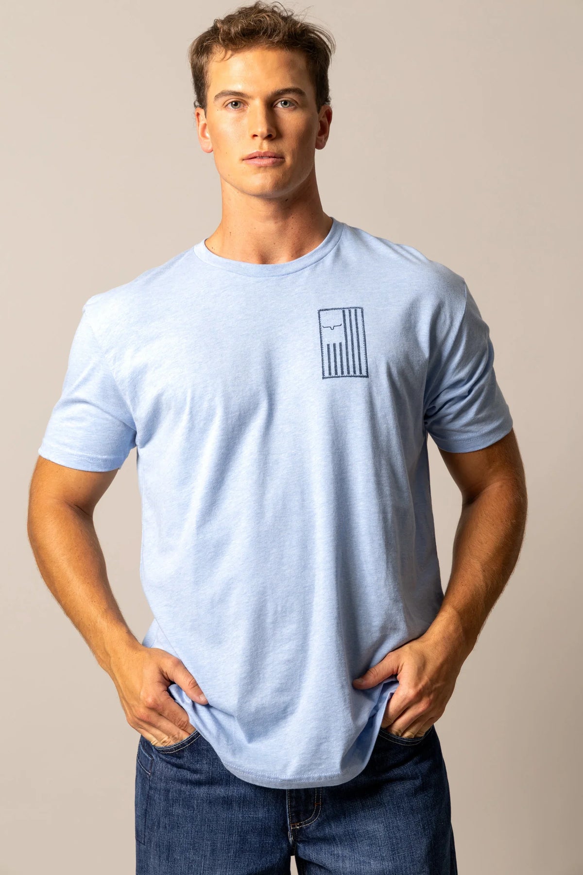 Kimes Ranch Patched shirt in Heather Columbia Blue with a chest graphic of the Kimes Ranch logo and vertical stripes