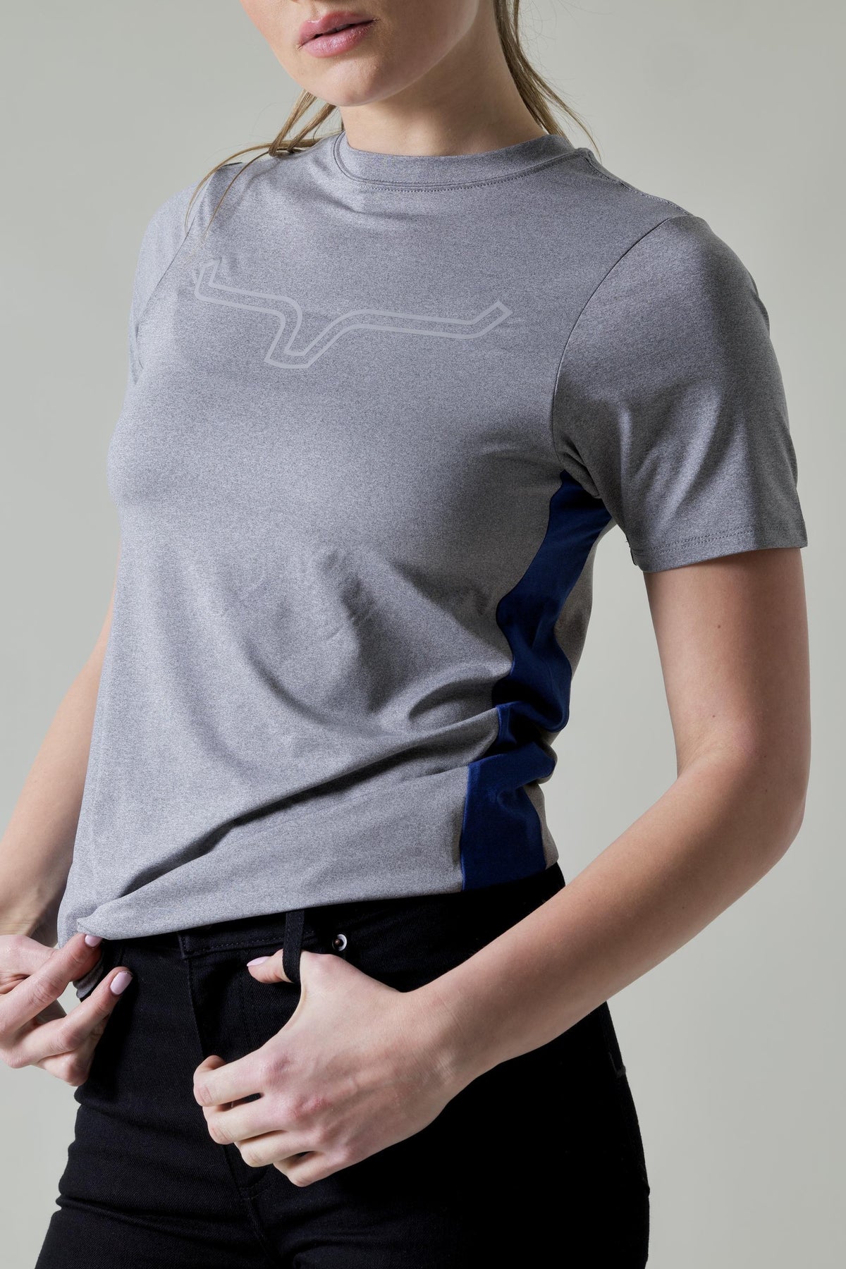 Kimes Ranch Ladies Phase 2 Tech Shirt in Grey Heather, side view, with a tonal logo and navy side panels