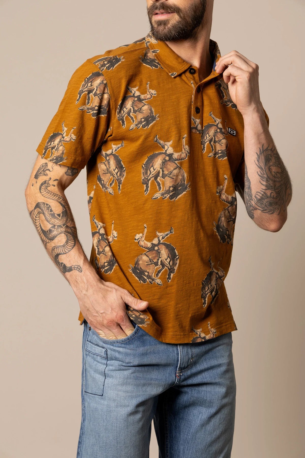 Kimes Ranch RP Winning Ride Polo in Work Wear Brown with an all-over print of a cowboy riding a bucking horse