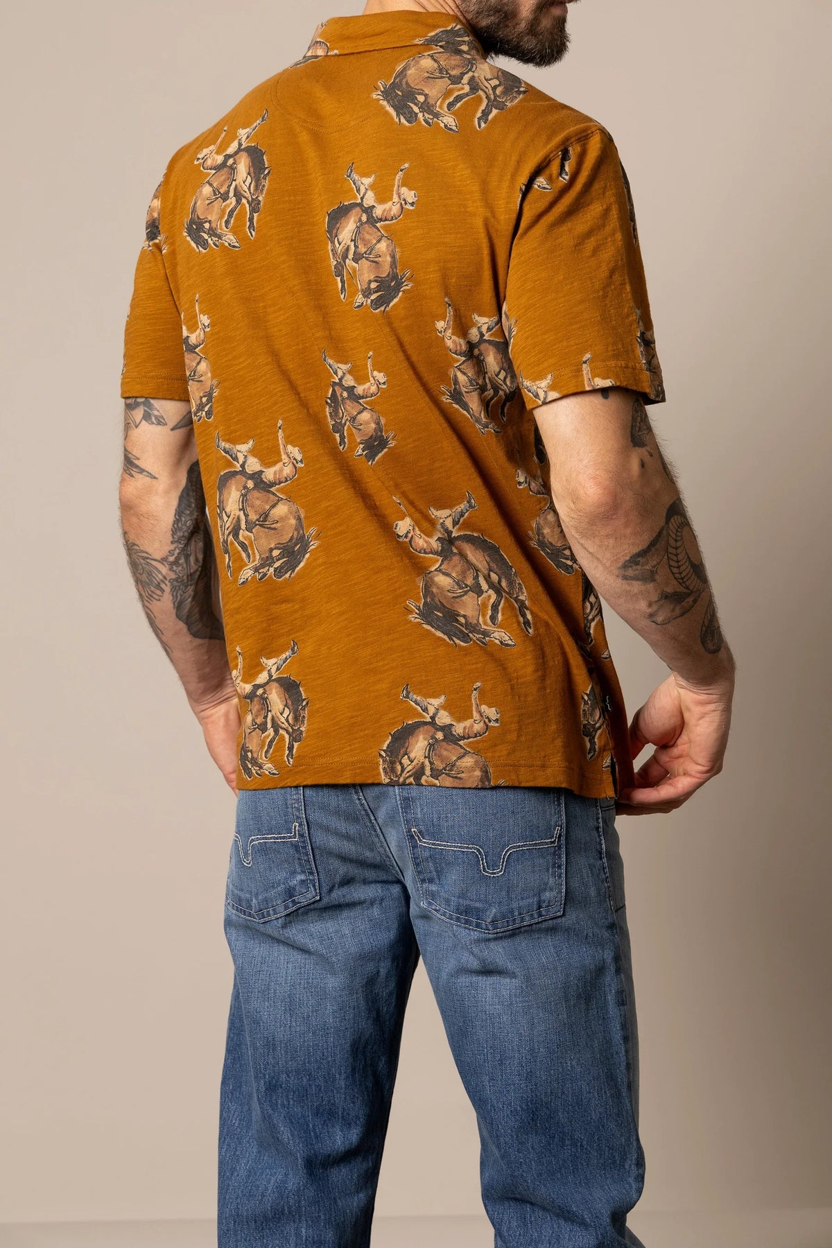 Kimes Ranch RP Winning Ride Polo in Work Wear Brown, back view, with all-over print of cowboys riding bucking broncos
