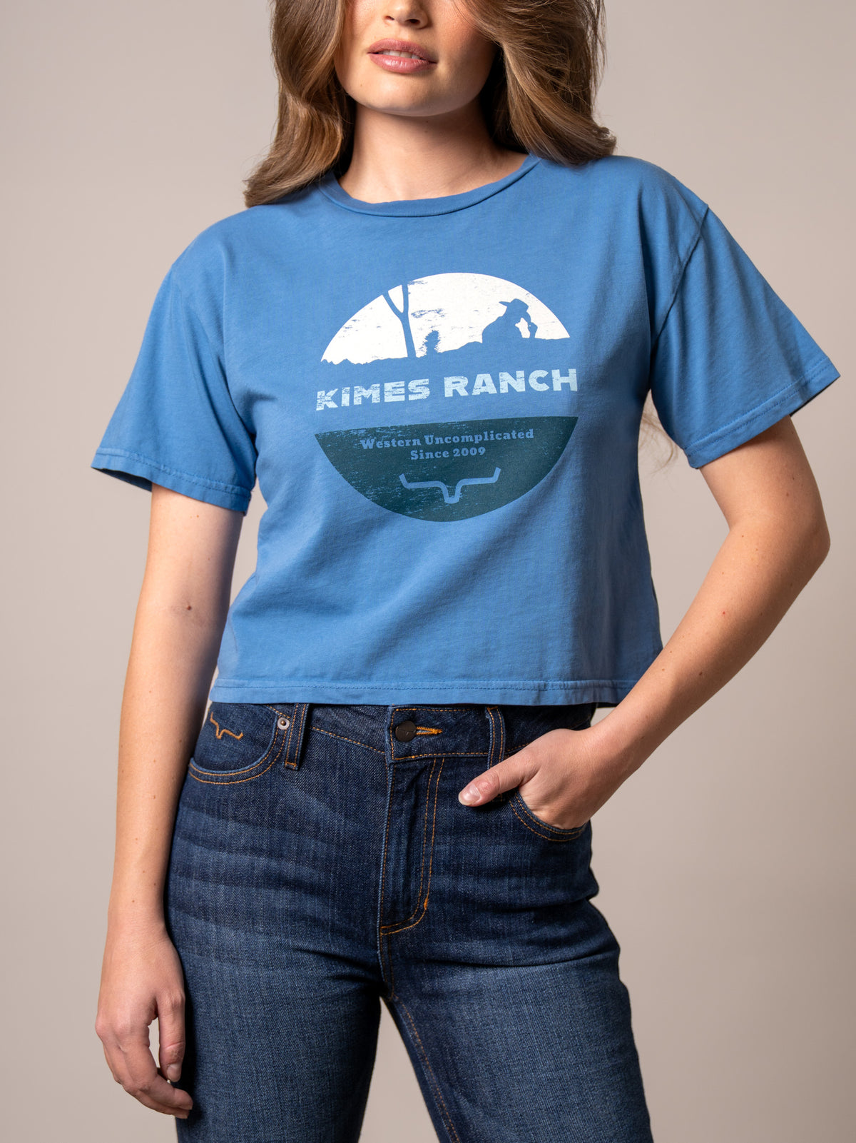 Kimes Ranch Rancher shirt in Carbon Blue with a graphic of a cowboy silhouette and the text Western Uncomplicated Since 2009