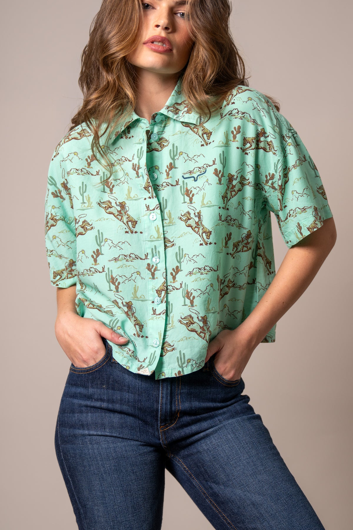 Kimes Ranch Ranchero top in Turquoise with a western print of cowboys and cacti