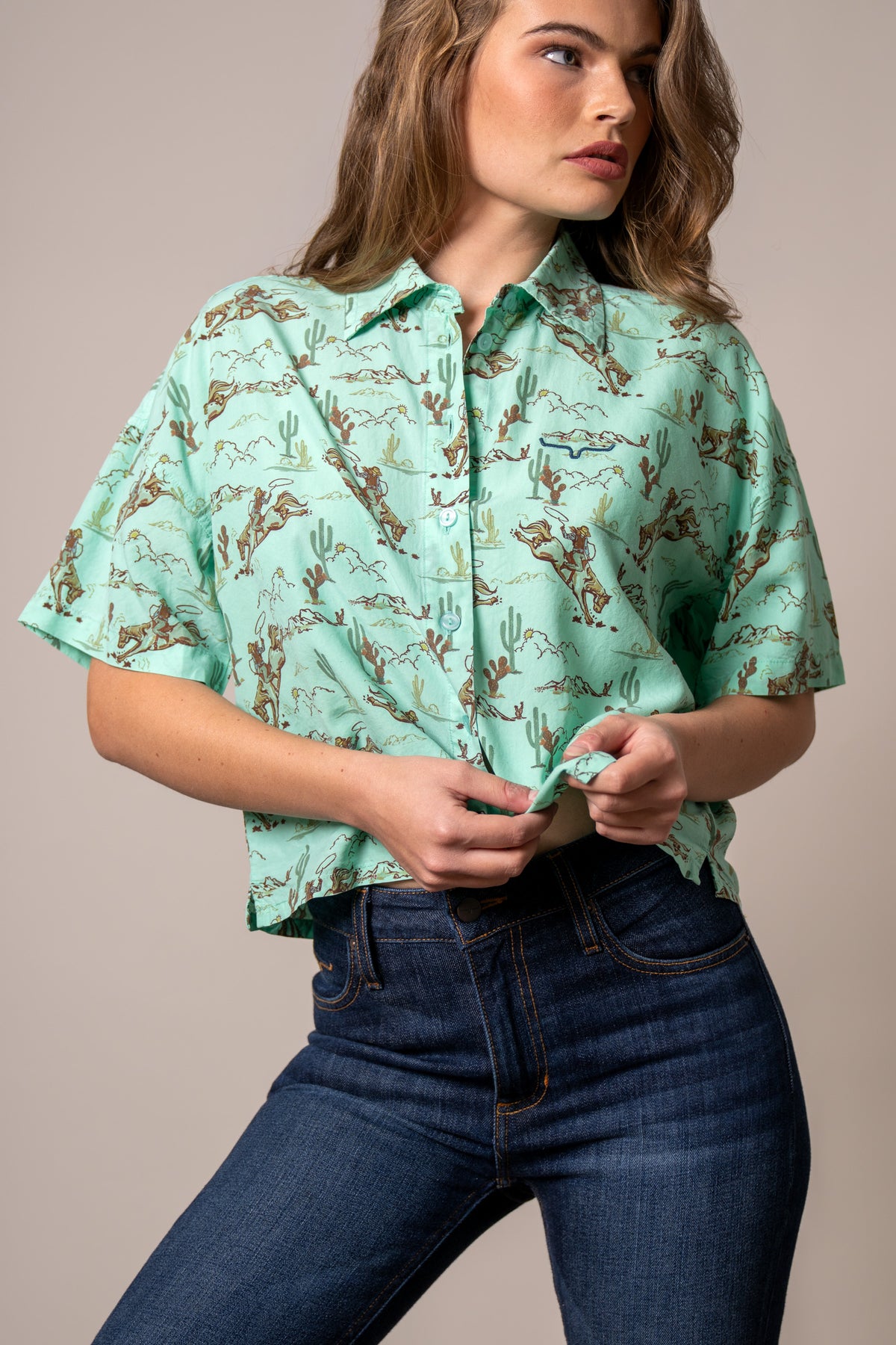 Kimes Ranch Ranchero top in Turquoise with a western print of cowboys and cacti