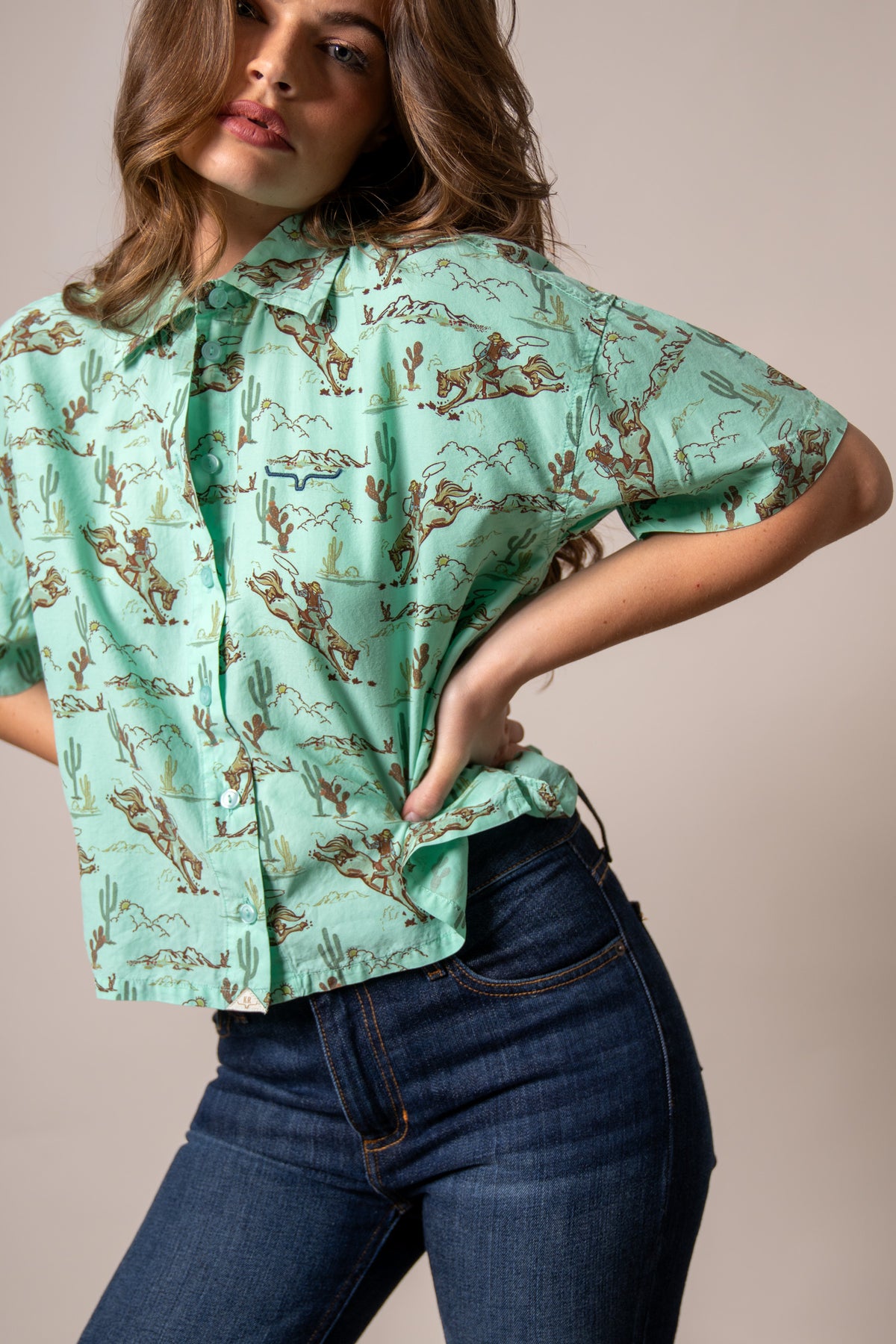 Kimes Ranch Ranchero top in Turquoise with a western print of cowboys and cacti