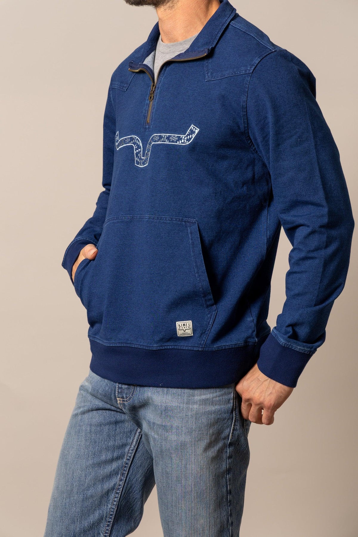 Kimes Ranch Rowell Pullover sweatshirt in Indigo, side view, with a front kangaroo pocket and a white graphic print