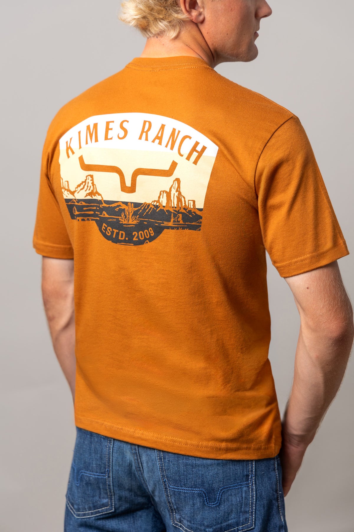 Kimes Ranch Southwestern shirt in Clay, back view, with a back graphic featuring the Kimes Ranch logo