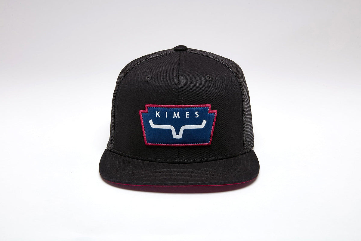 Kimes Ranch Texola Black trucker hat with a front embroidered logo patch featuring the brand name and a stylized steer mark