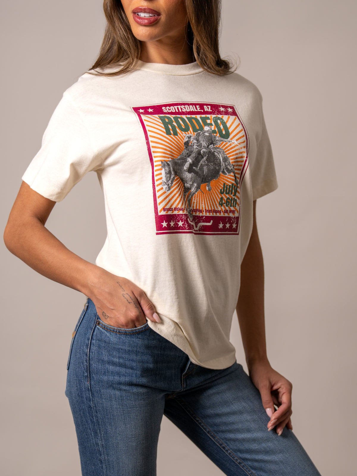 Kimes Ranch Top Bill Cream shirt with a Scottsdale rodeo graphic featuring a cowboy on a bucking horse