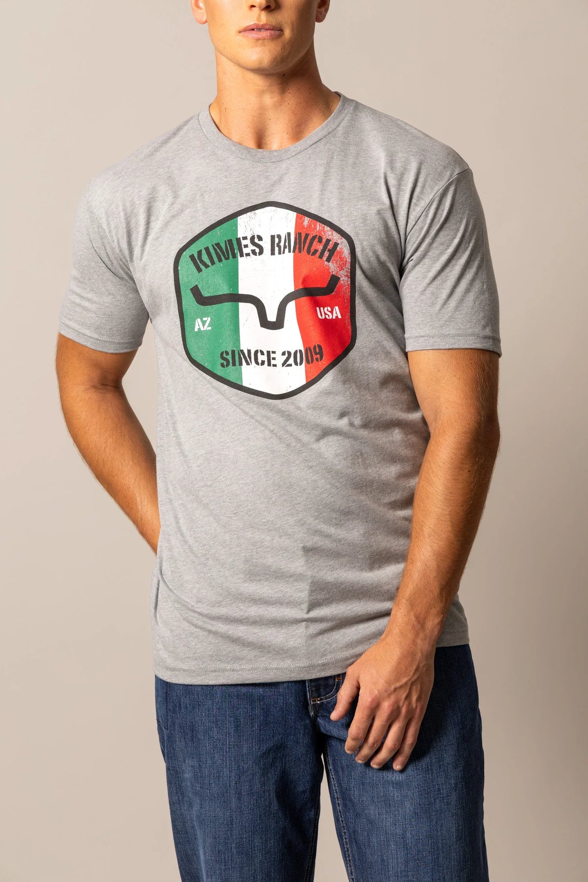 Kimes Ranch Triple Stripe shirt in Dark Grey Heather with a shield graphic featuring the Kimes Ranch logo