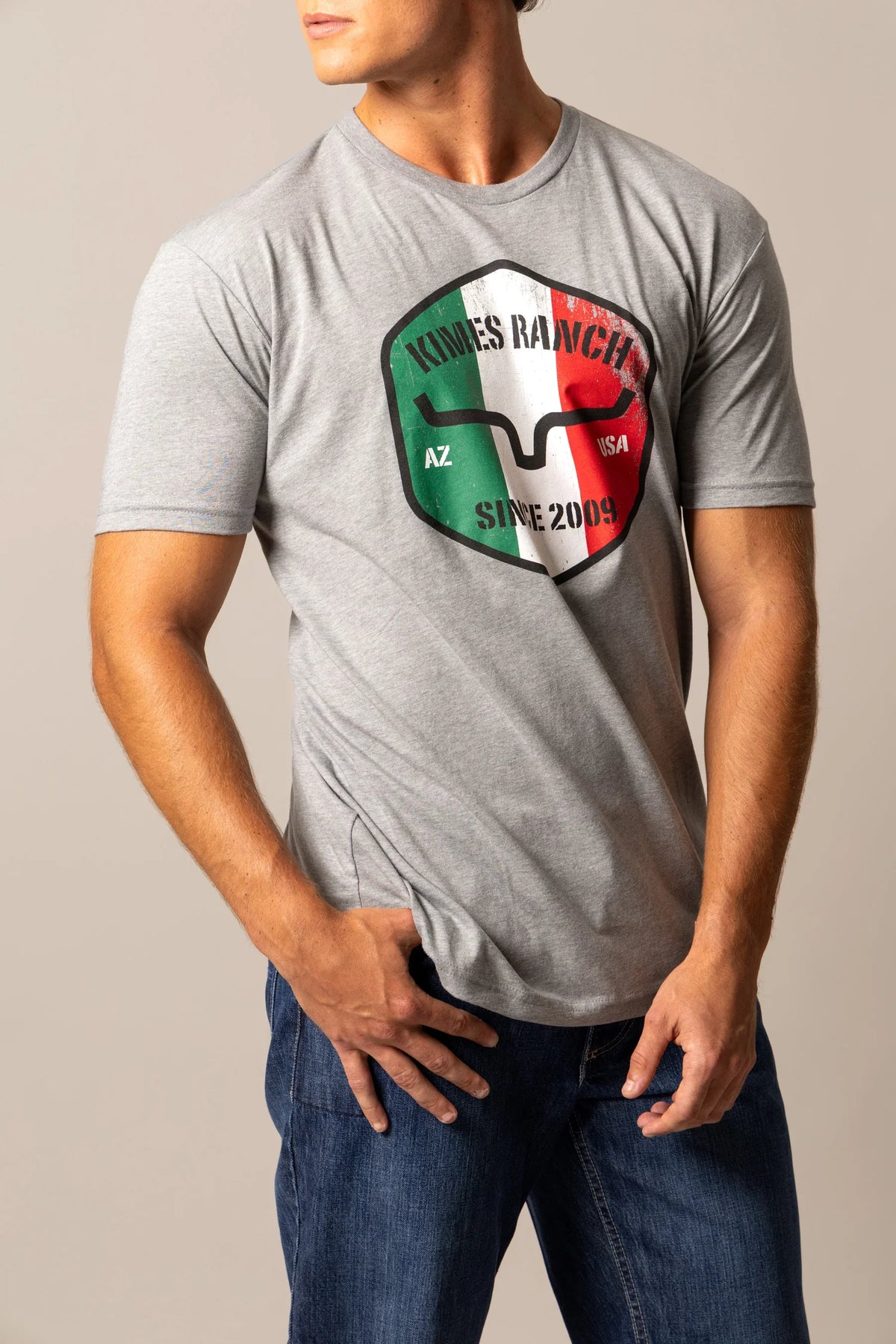 Kimes Ranch Triple Stripe shirt in Dark Grey Heather with a shield graphic featuring the Kimes Ranch logo