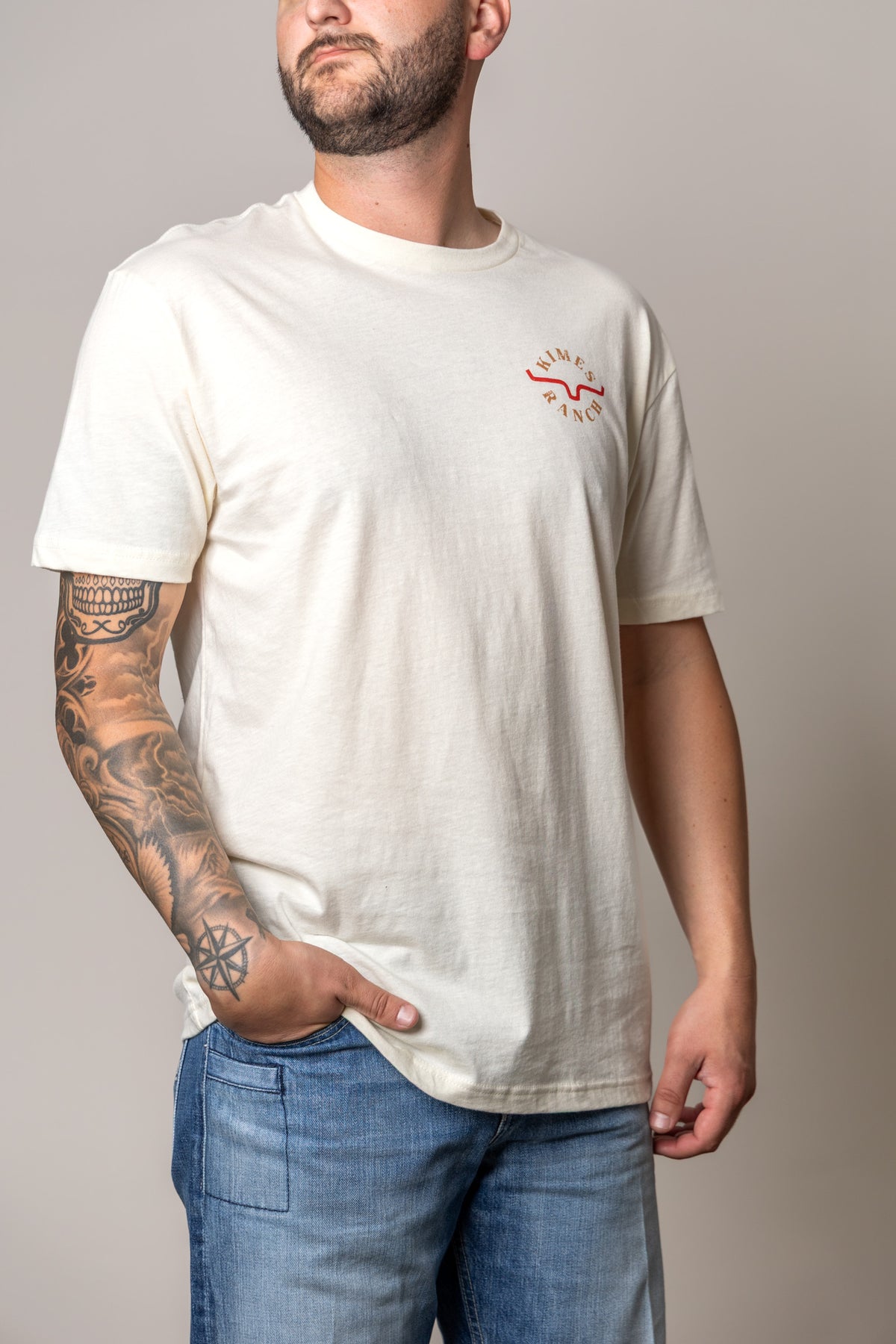 Kimes Ranch Uncomplicated shirt in Natural with a short sleeve crewneck and chest logo