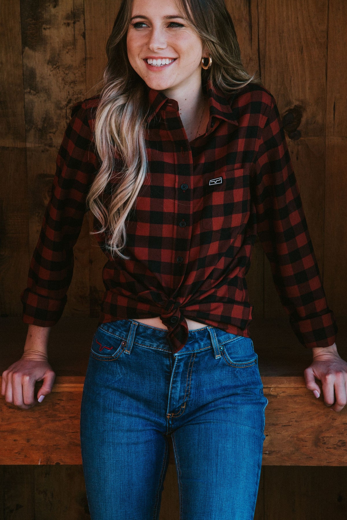 Kimes Ranch Ladies Garrison long sleeve button-up top in red and black plaid with a front pocket and logo