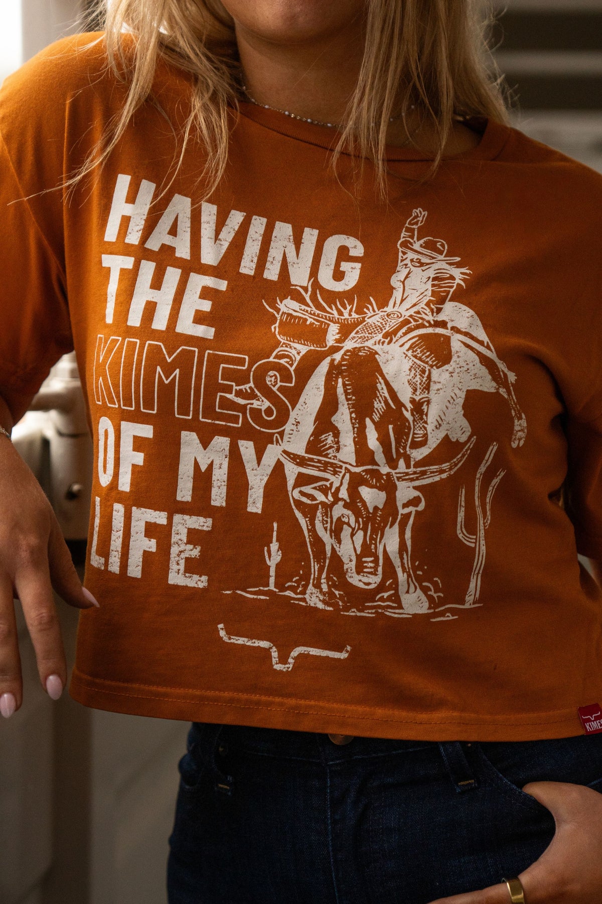 Kimes Ranch Kimes Of My Life shirt in Rust with a graphic of a cowboy riding a steer and the text Having The Kimes Of My Life