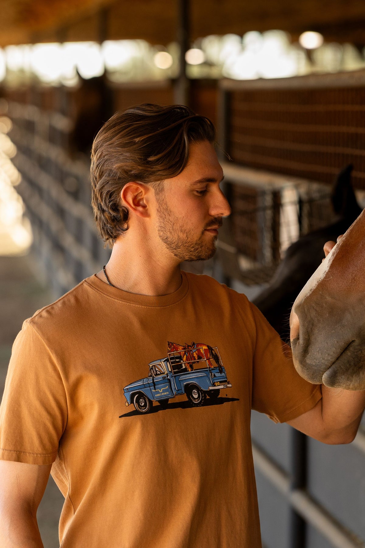 Kimes Ranch Lucky B Truck shirt in Work Wear Brown with a blue truck graphic carrying a horse