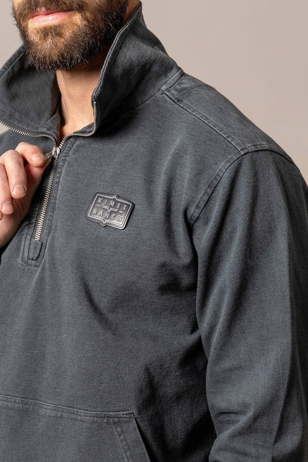 Kimes Ranch Wicklow sweatshirt in Charcoal with a close-up of the half-zip collar and logo patch