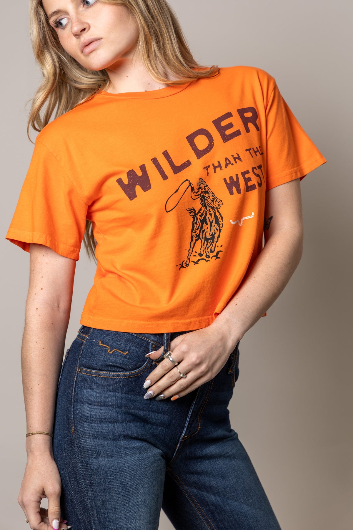 Kimes Ranch Wilder Than The West shirt in Vintage Orange with a cowboy on a bucking horse graphic