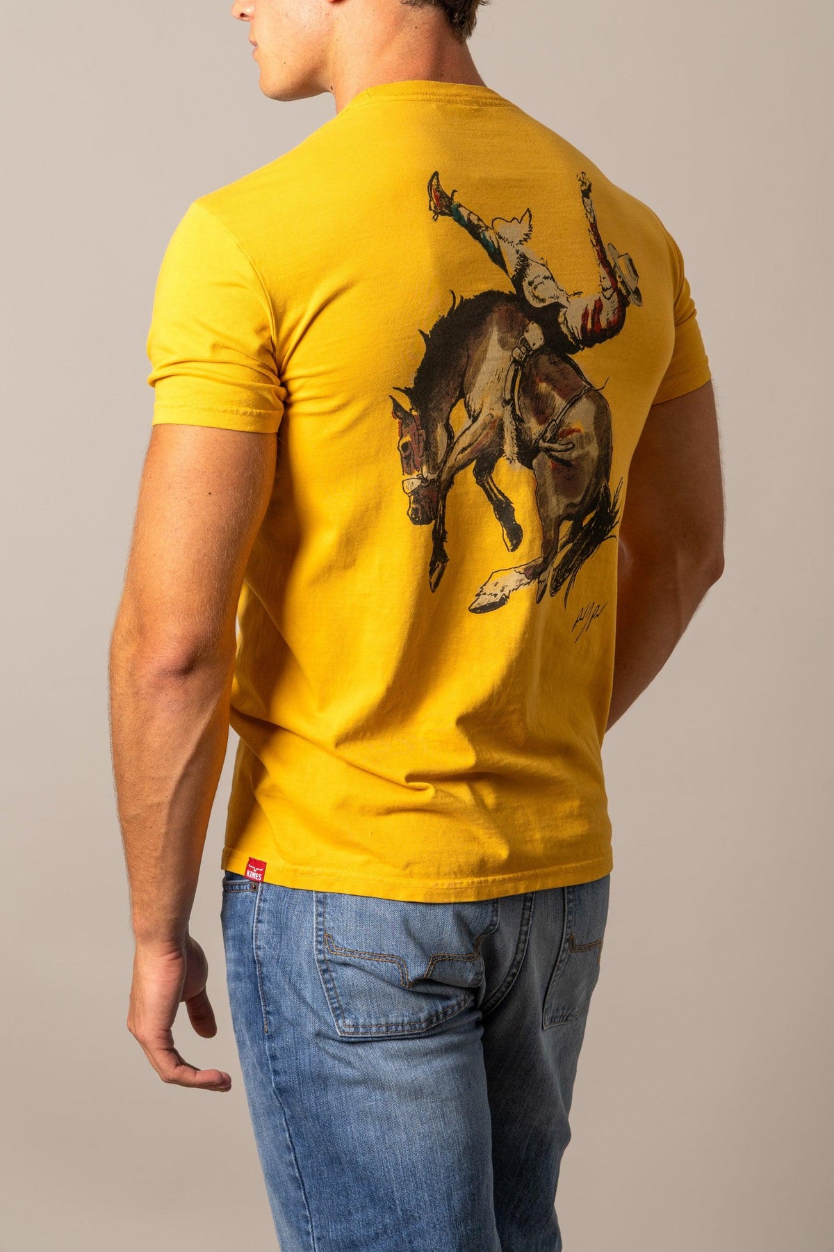 Kimes Ranch Winning Ride RP shirt in Yellow Ochre, back view, with a back graphic of a cowboy riding a bucking horse