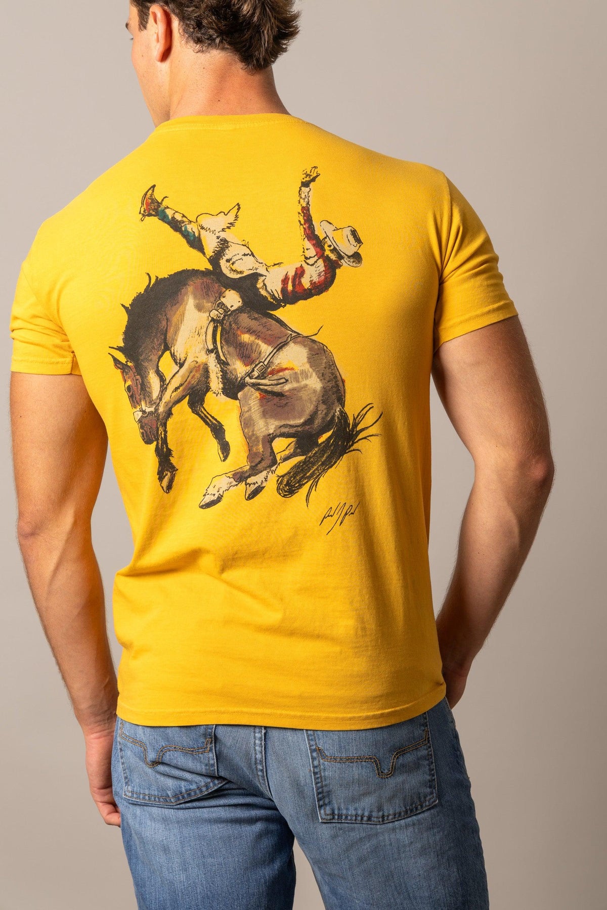 Kimes Ranch Winning Ride RP shirt in Yellow Ochre, back view, with a back graphic of a cowboy riding a bucking horse