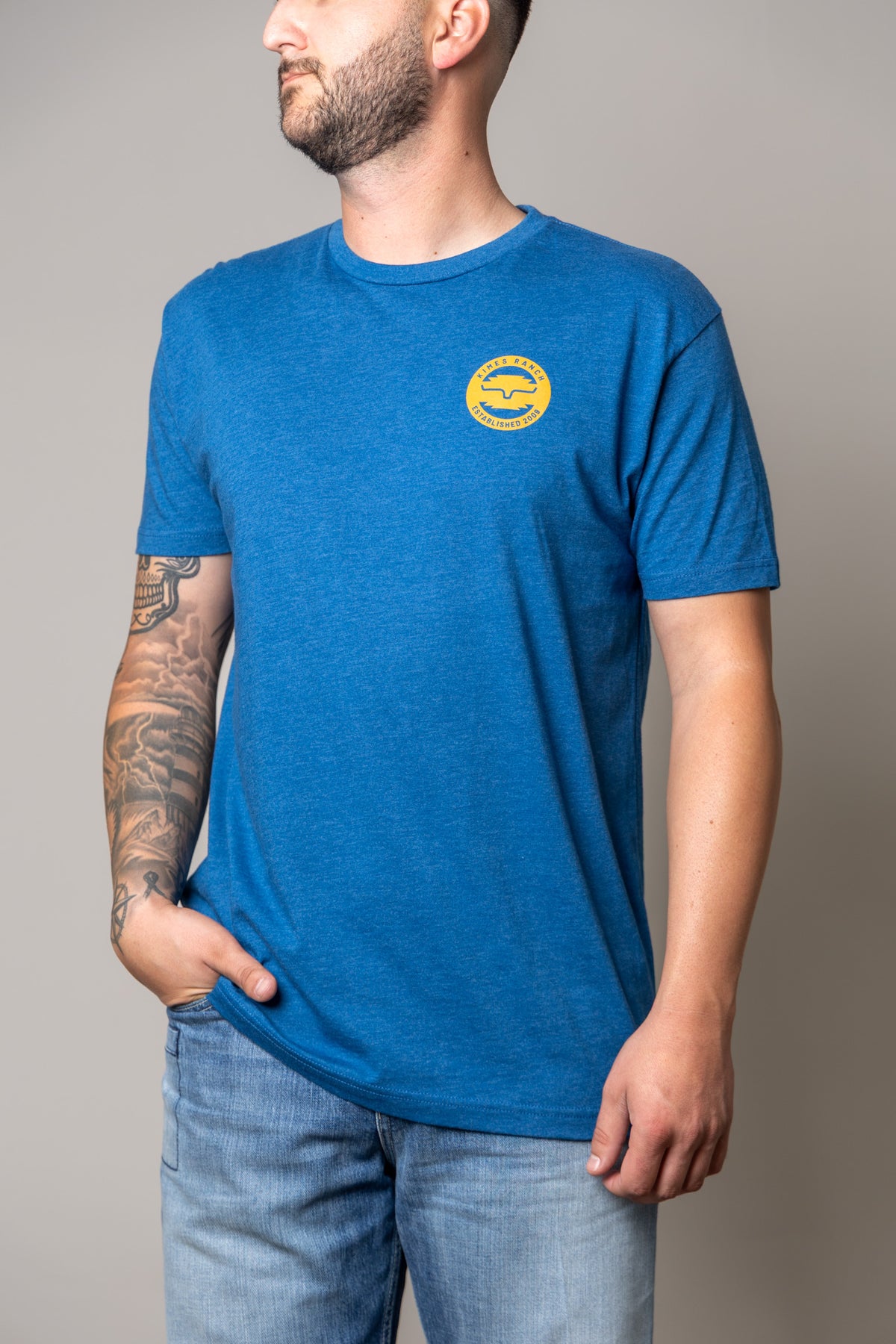 Kimes Ranch Wood Stamp shirt in Heather Cool Blue with a yellow Kimes Ranch logo on the chest