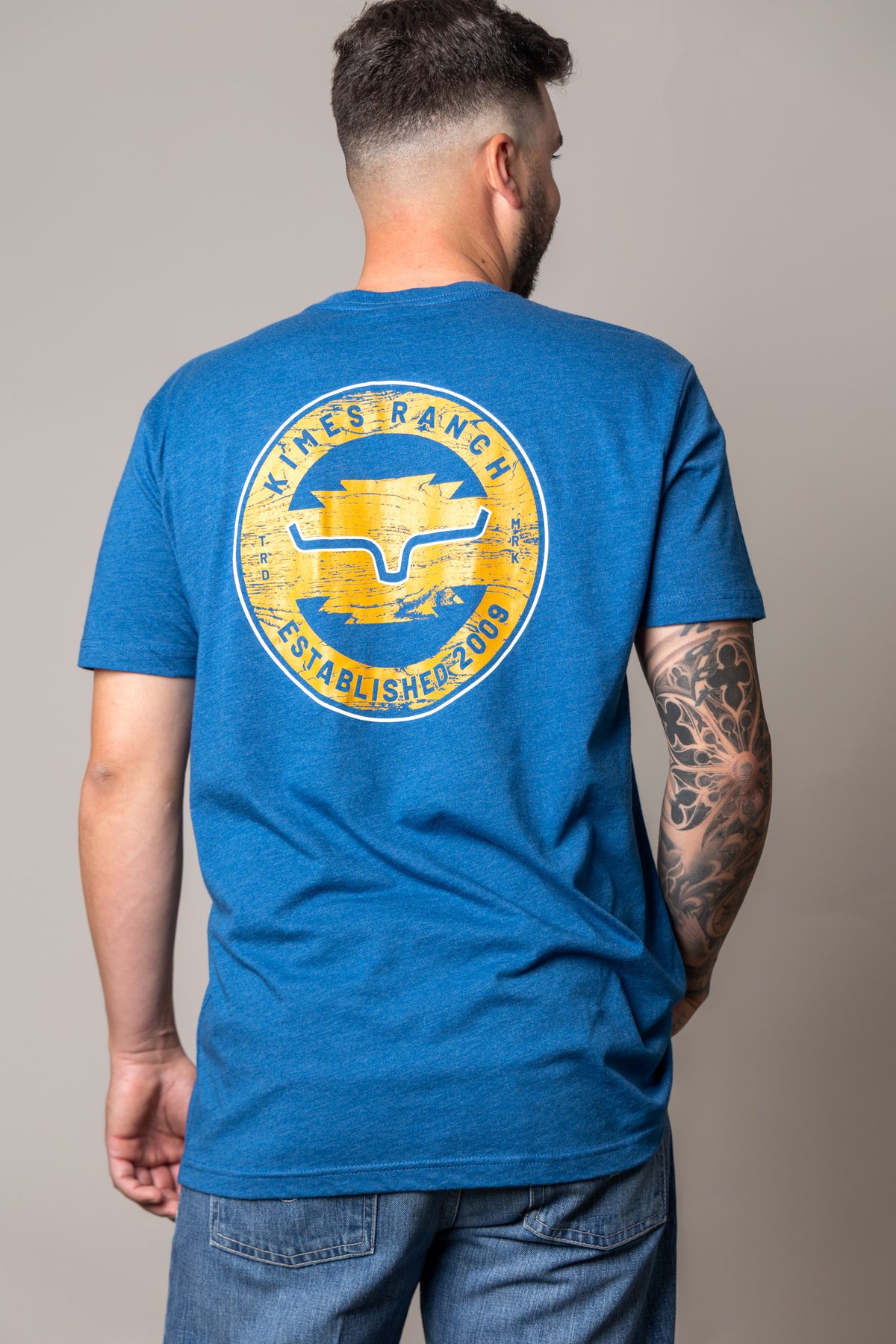 Kimes Ranch Wood Stamp shirt in Heather Cool Blue, back view, with a large circular back graphic