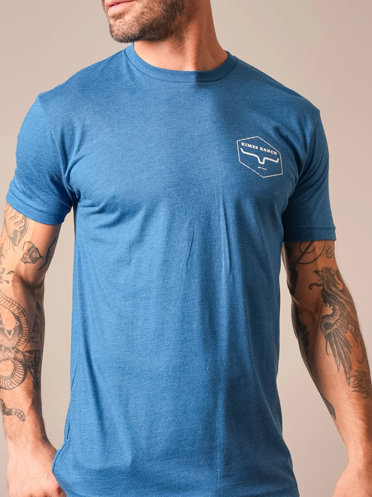 Kimes Ranch Wooden Hex shirt in Heather Cool Blue with a white Kimes Ranch logo on the chest