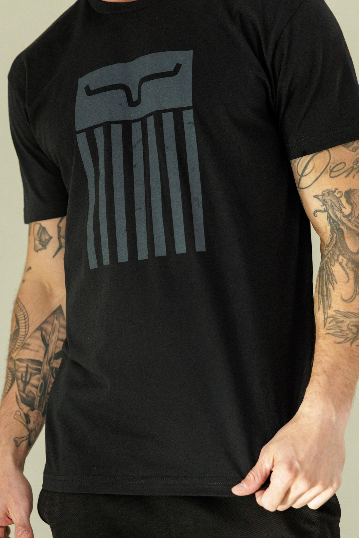 Kimes Ranch Cody Tee Shirt in Black with a large graphic featuring a stylized Kimes Ranch logo and vertical stripes