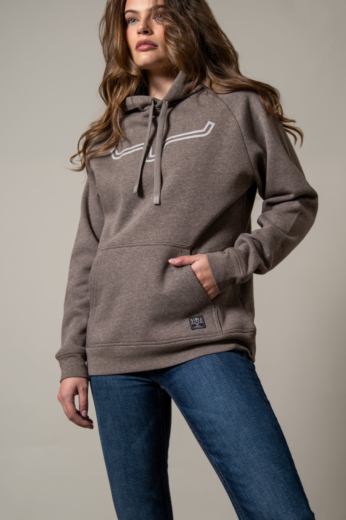 Kimes Ranch Ladies Outlier Hoodie in Dark Brown with a front kangaroo pocket and a white logo graphic