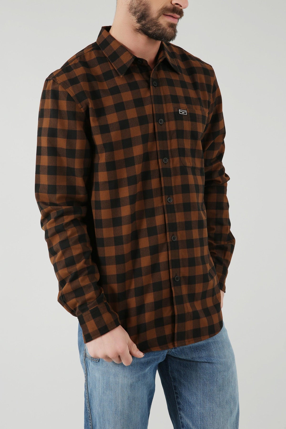 Kimes Ranch Garrison Dress Shirt in Brown, side view, with a black check pattern and a chest pocket with the Kimes Ranch logo