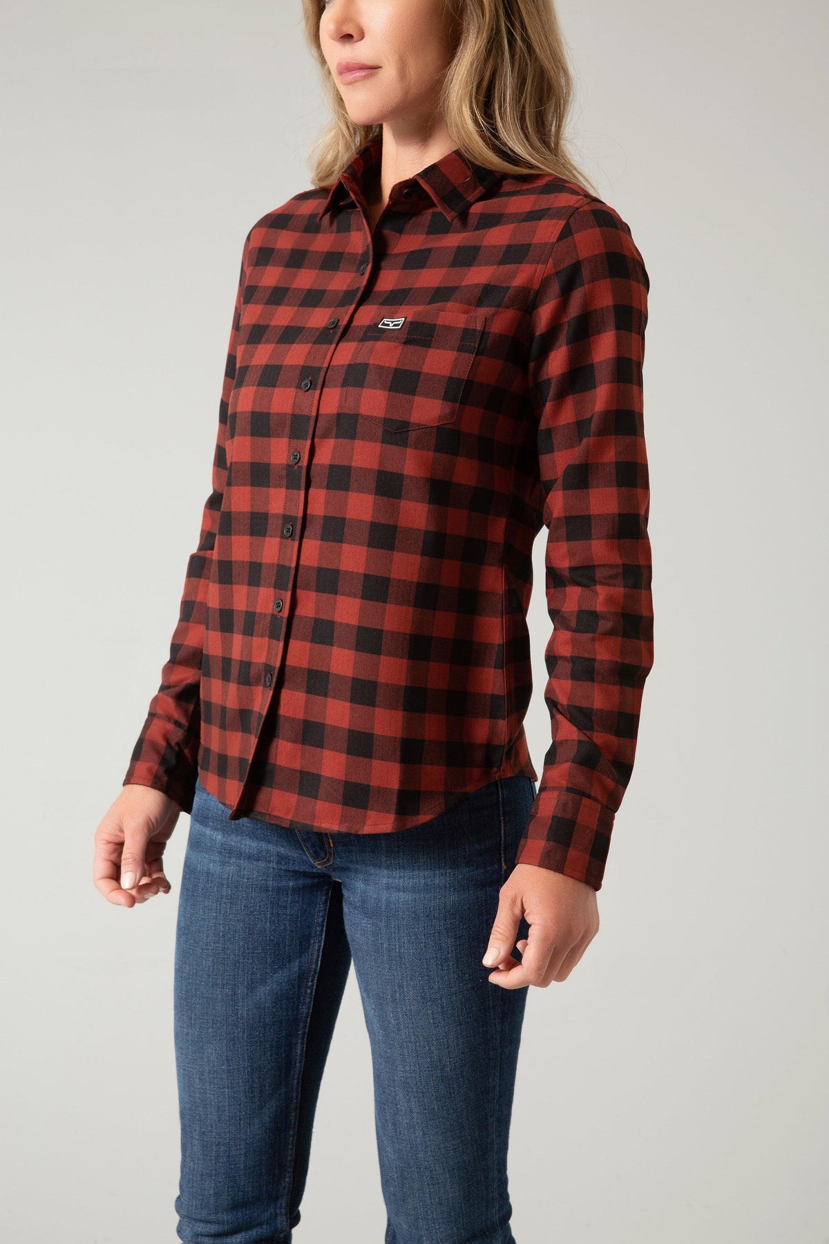 Kimes Ranch Ladies Garrison, side view, long sleeve button-up top in red and black buffalo plaid with a chest pocket and logo