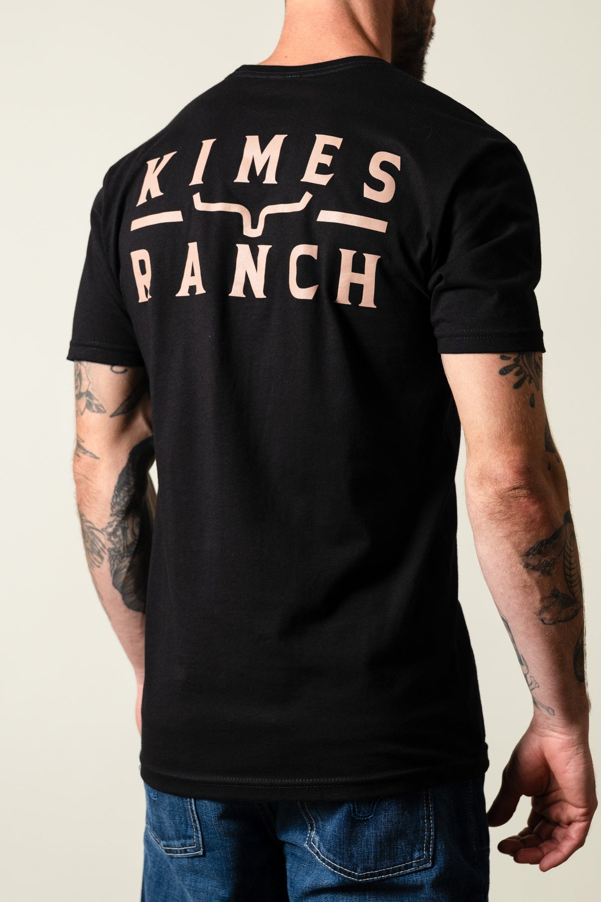 Back of Kimes Ranch Back Branded Shirt in black showing large logo print with stylized horn across upper back