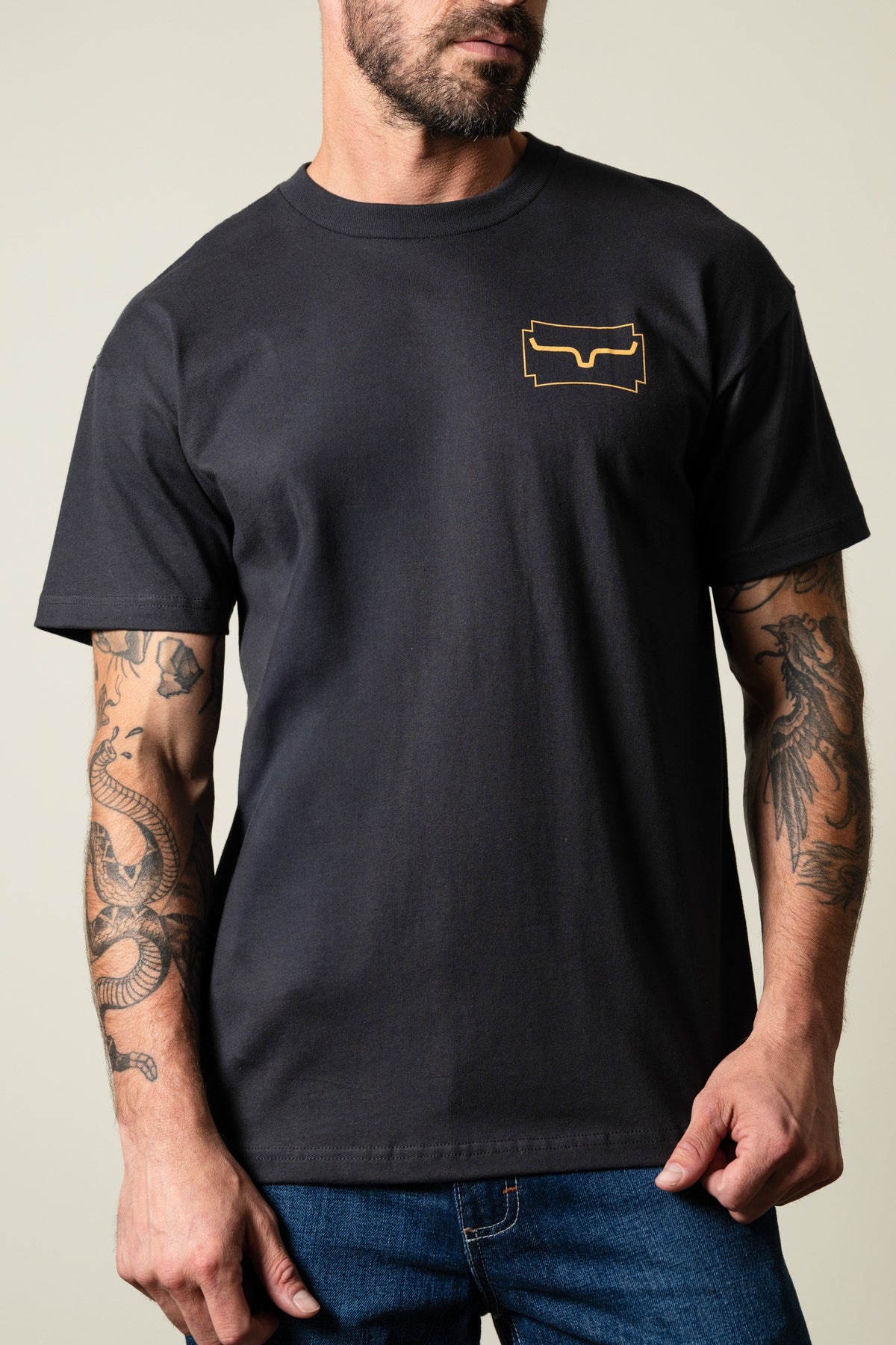 Kimes Ranch Camo Crest t-shirt in graphite black with a short-sleeve crew neck and a gold Kimes Ranch logo on the left chest