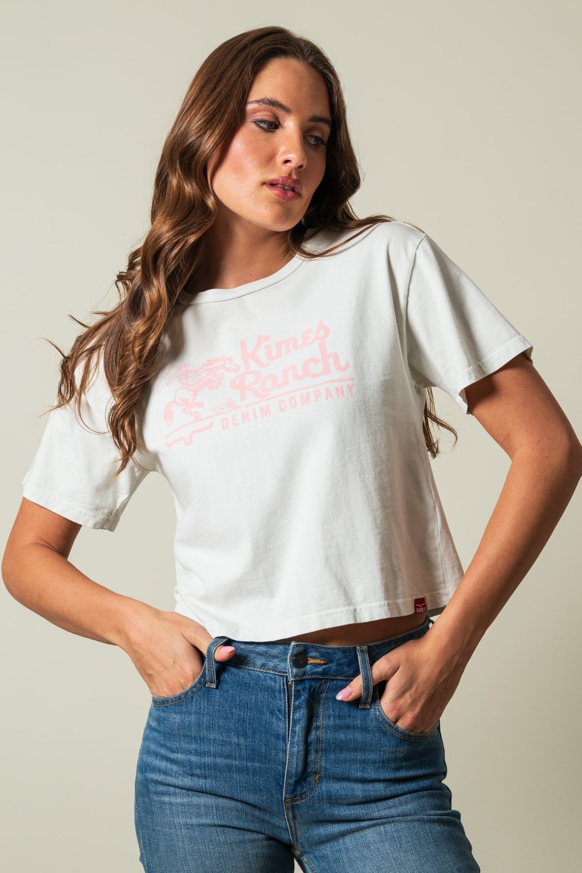 Kimes Ranch Davona Dale Natural short-sleeve crewneck crop top featuring pink Kimes Ranch Denim Company logo on the front