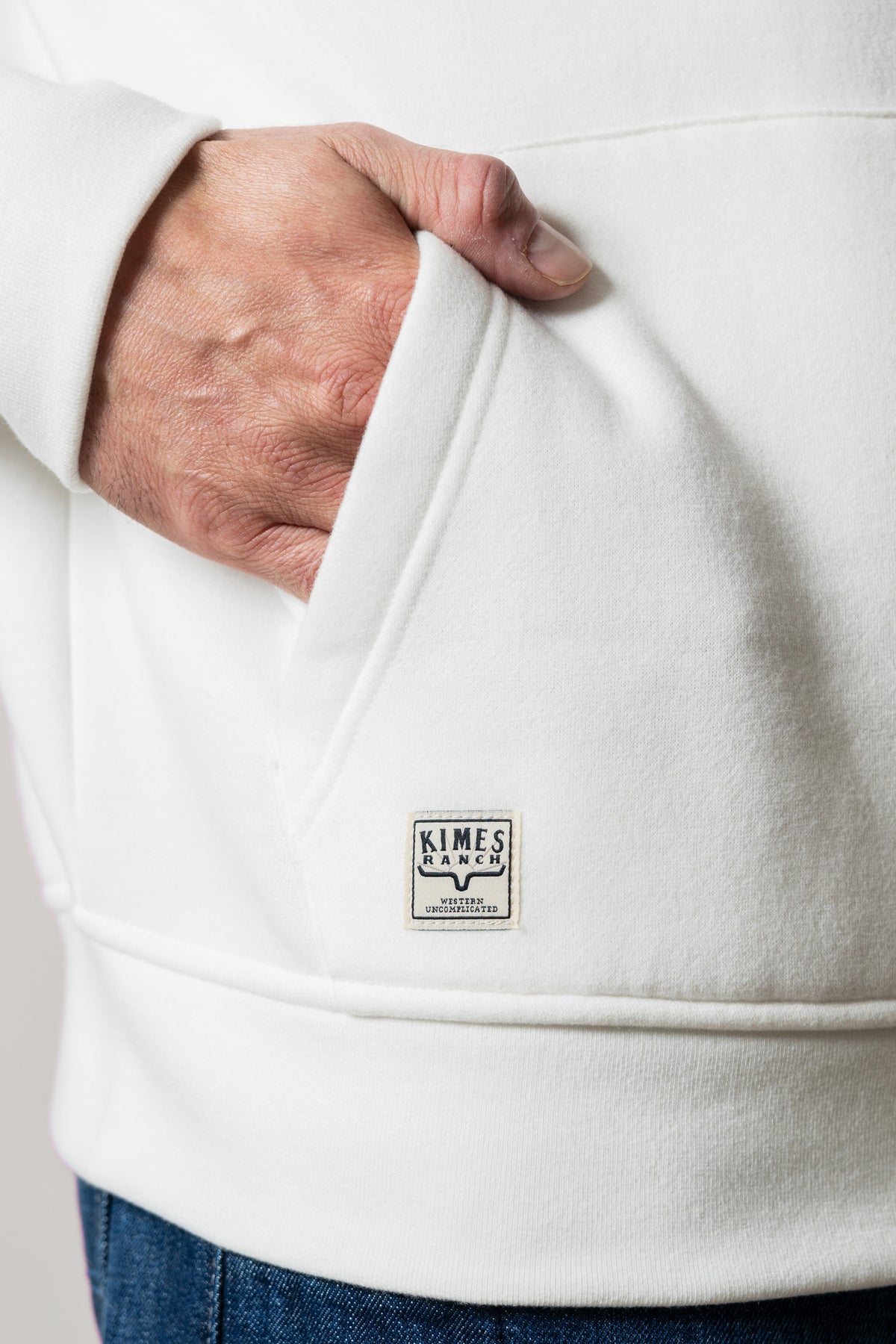 Kimes Ranch Mallard hoodie in Natural with hand in front kangaroo pocket and woven Kimes Ranch logo