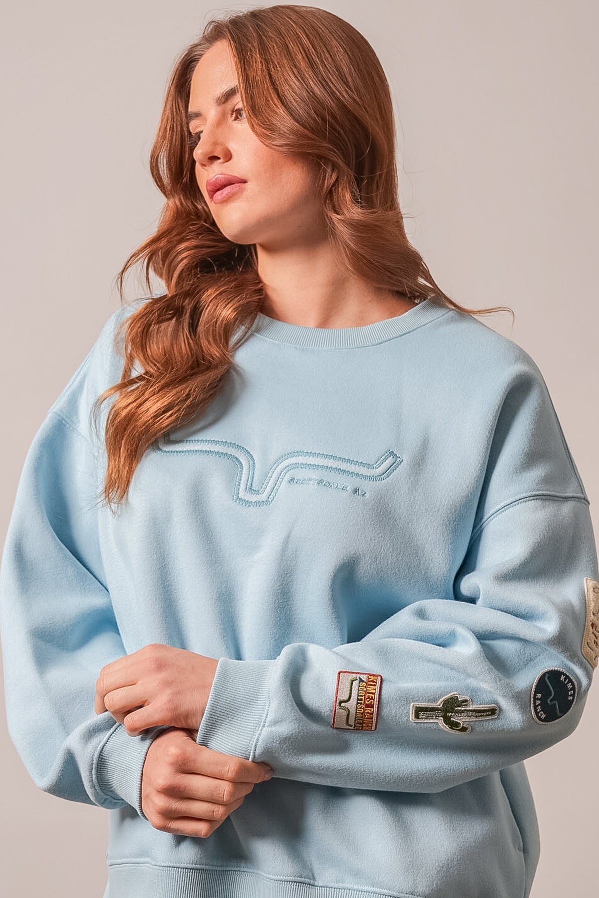 Kimes Ranch Saguaro Patch Sweatshirt in Faded Denim, featuring embroidered road graphic, cactus patch, and logos on sleeves
