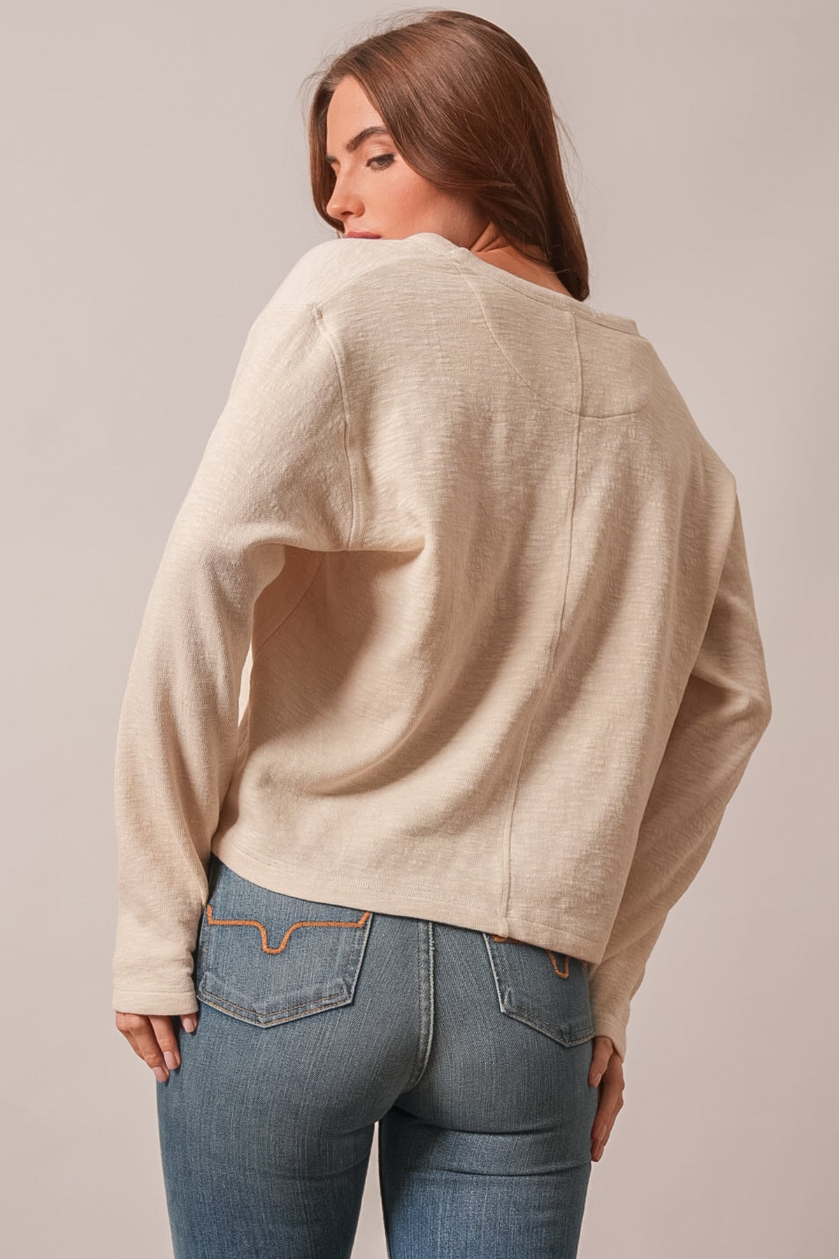 Kimes Ranch Sidney long sleeve knit top in Natural shown from the back with raglan sleeves and curved hem