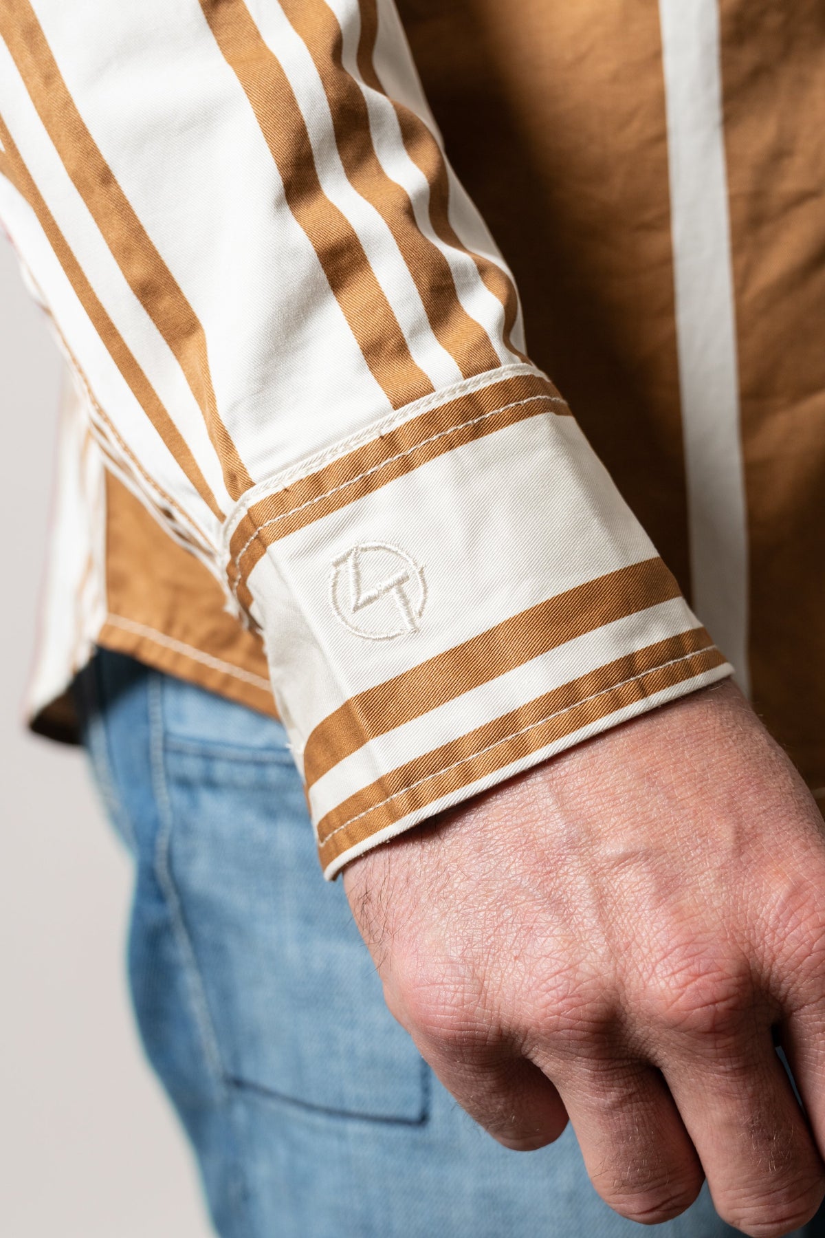 Kimes Ranch ZT 1 Arm Bandit Natural dress shirt featuring white and tan vertical stripes with a Kimes Ranch logo on the cuff