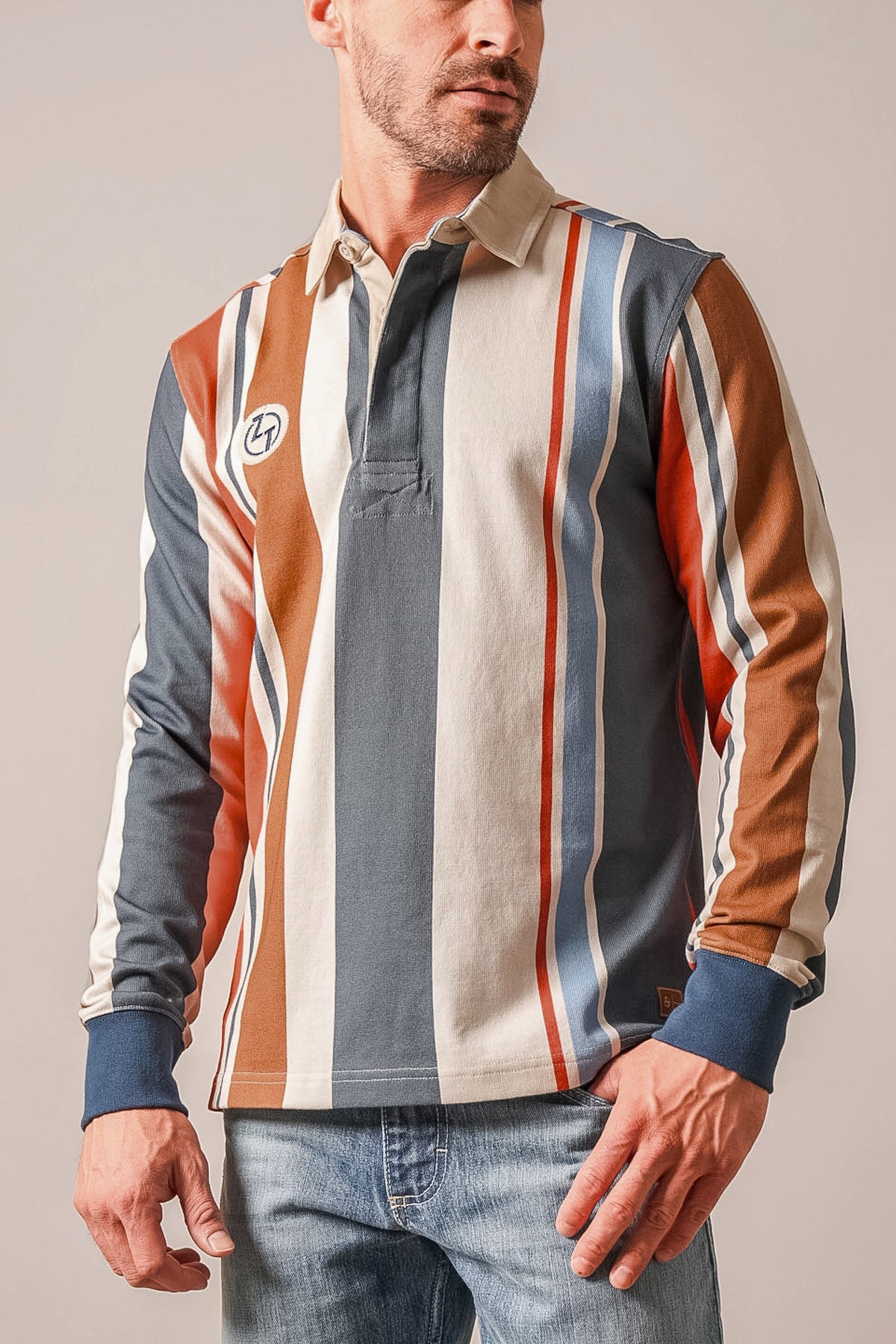 Kimes Ranch ZT Wyatt polo with Dark Blue, orange, and cream vertical stripes and a chest logo