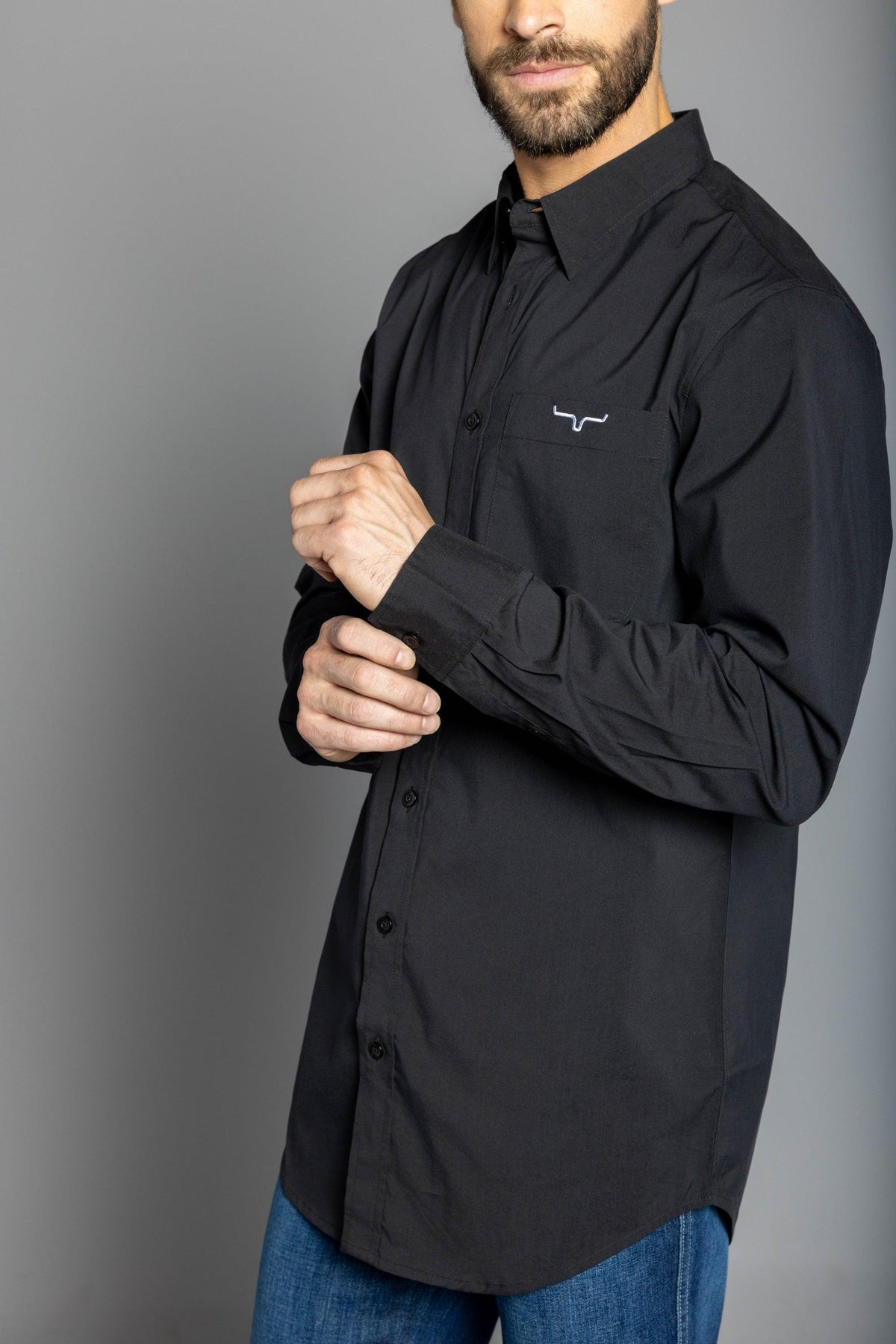 Kimes Ranch KR Team Dress Shirt in Black, side view, with long sleeves and a chest pocket featuring the Kimes Ranch logo